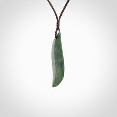 This is a lovely New Zealand Jade, pounamu drop pendant. Hand carved for us by Ric Moor. It is bound with an adjustable brown coloured cord which is length adjustable. Free worldwide shipping.