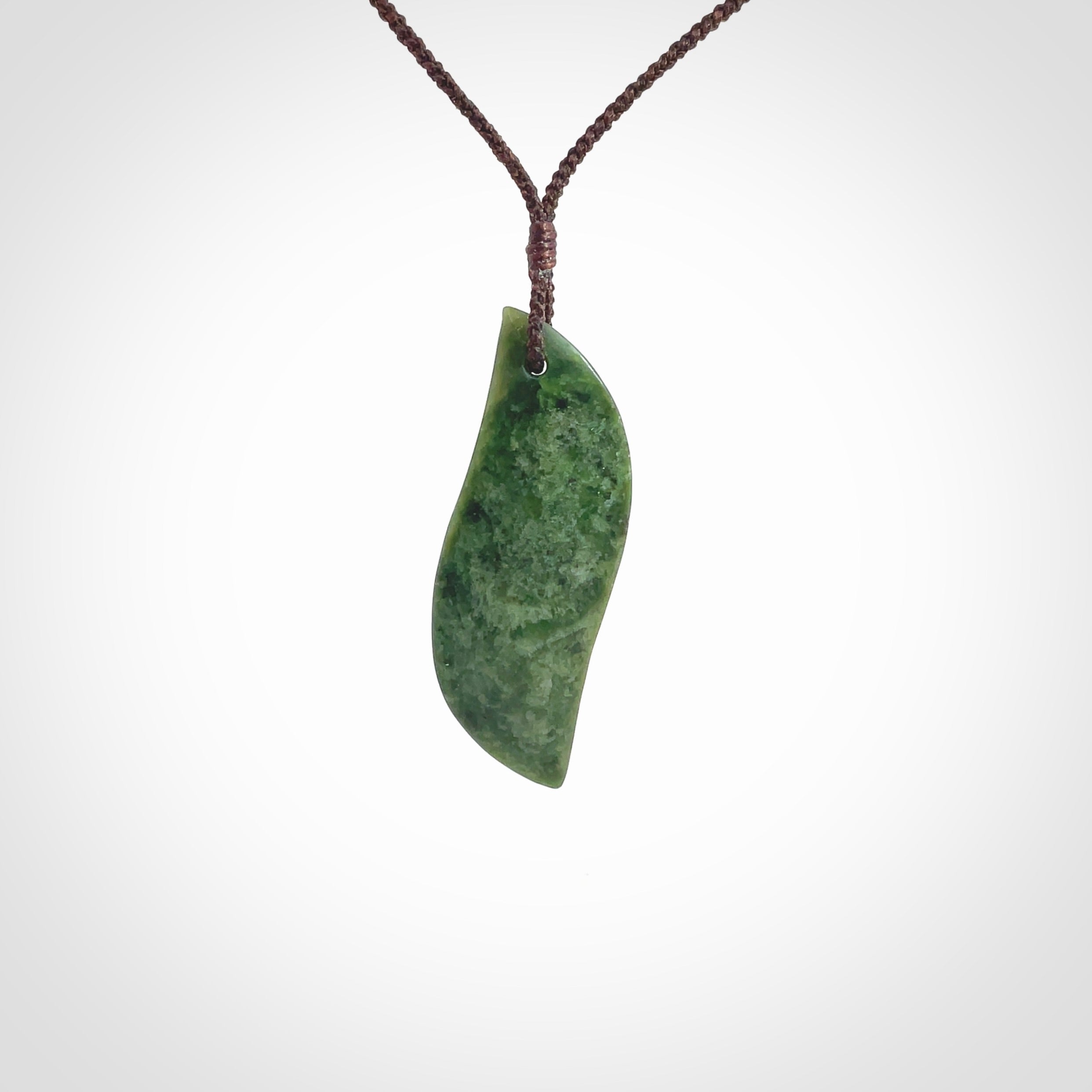 This is a lovely New Zealand Jade, pounamu drop pendant. Hand carved for us by Ric Moor. It is bound with an adjustable brown coloured cord which is length adjustable. Free worldwide shipping.