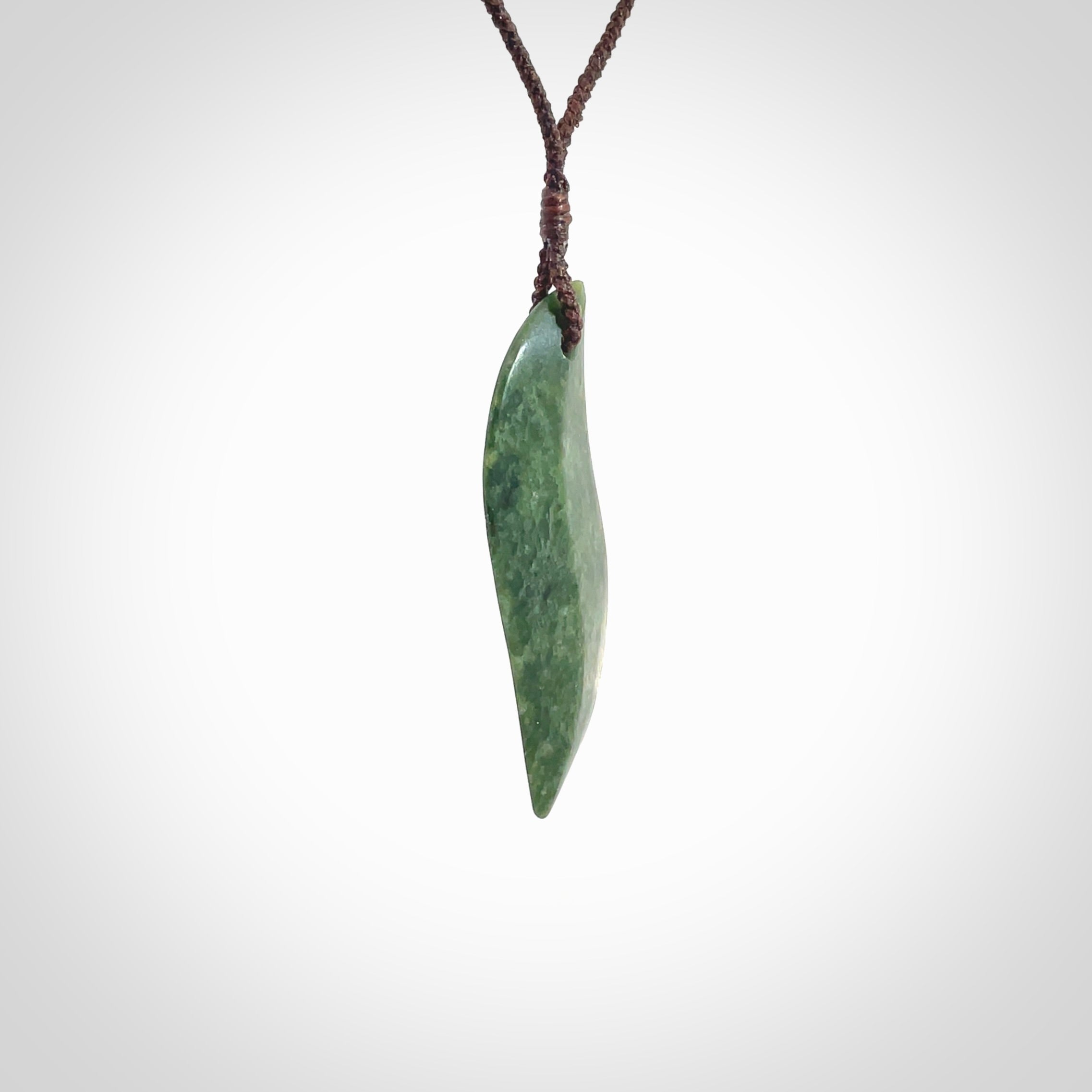 This is a lovely New Zealand Jade, pounamu drop pendant. Hand carved for us by Ric Moor. It is bound with an adjustable brown coloured cord which is length adjustable. Free worldwide shipping.