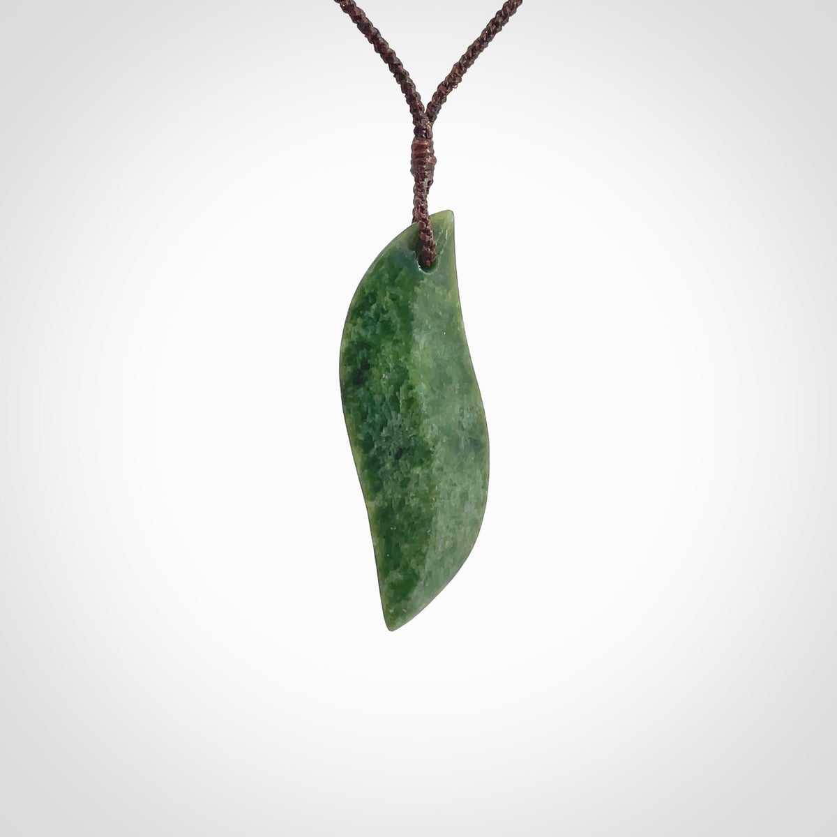 This is a lovely New Zealand Jade, pounamu drop pendant. Hand carved for us by Ric Moor. It is bound with an adjustable brown coloured cord which is length adjustable. Free worldwide shipping.