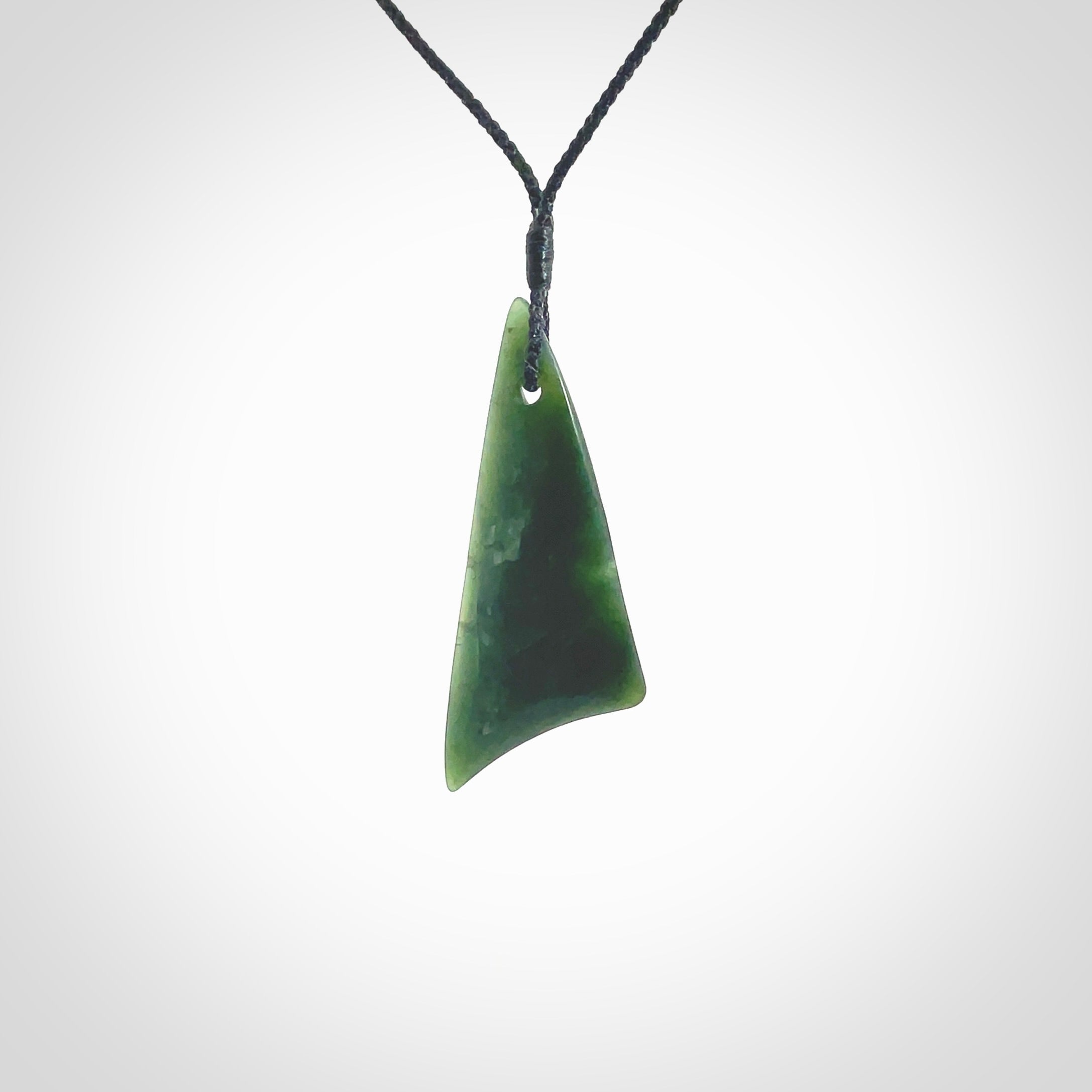 Hand carved pounamu drop pendant. Jade necklace hand made in New Zealand. A contemporary drop pendant carved from rare New Zealand jade. NZ Pacific jade jewellery for sale online. Provided with an adjustable black cord and packaged in a woven kete pouch.