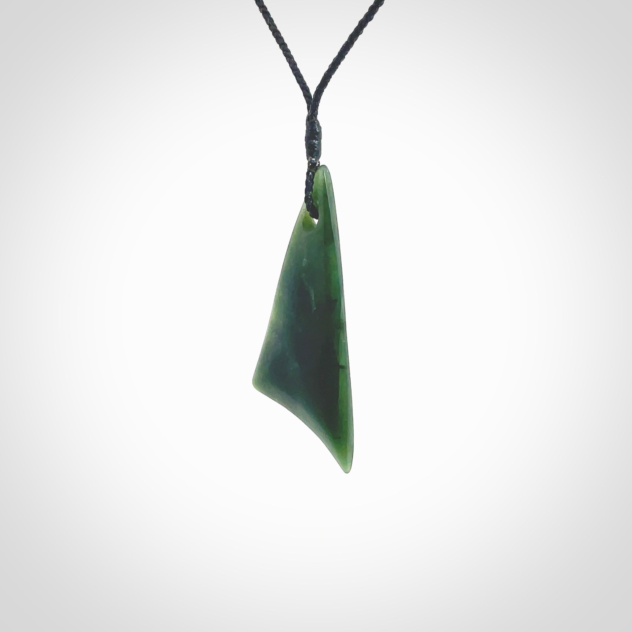 Hand carved pounamu drop pendant. Jade necklace hand made in New Zealand. A contemporary drop pendant carved from rare New Zealand jade. NZ Pacific jade jewellery for sale online. Provided with an adjustable black cord and packaged in a woven kete pouch.