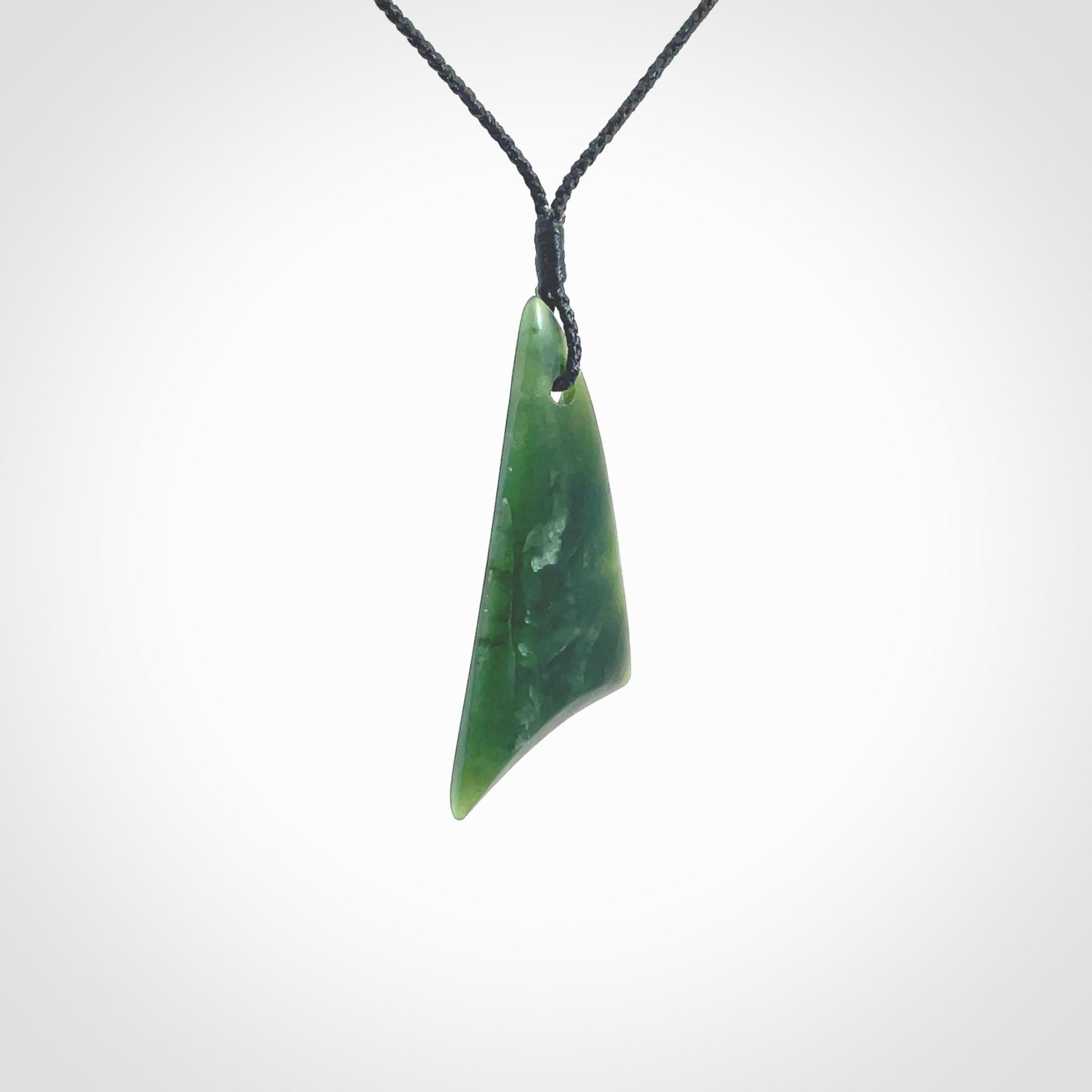 Hand carved pounamu drop pendant. Jade necklace hand made in New Zealand. A contemporary drop pendant carved from rare New Zealand jade. NZ Pacific jade jewellery for sale online. Provided with an adjustable black cord and packaged in a woven kete pouch.