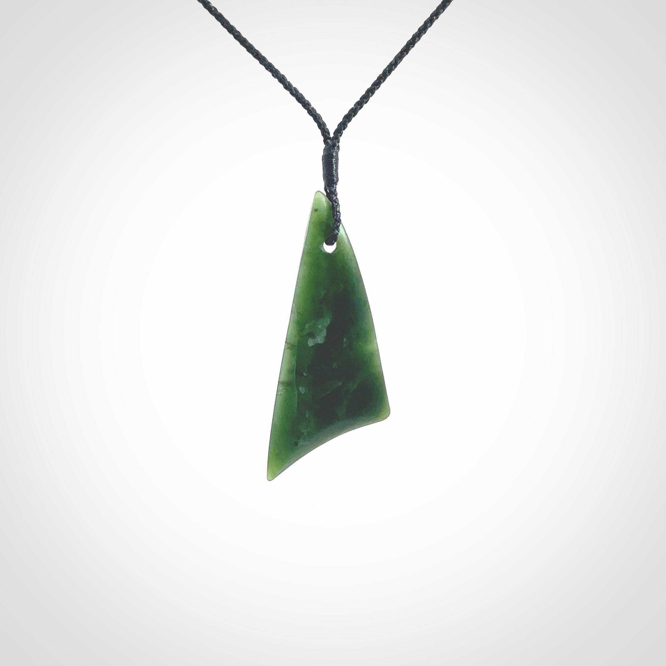 Hand carved pounamu drop pendant. Jade necklace hand made in New Zealand. A contemporary drop pendant carved from rare New Zealand jade. NZ Pacific jade jewellery for sale online. Provided with an adjustable black cord and packaged in a woven kete pouch.