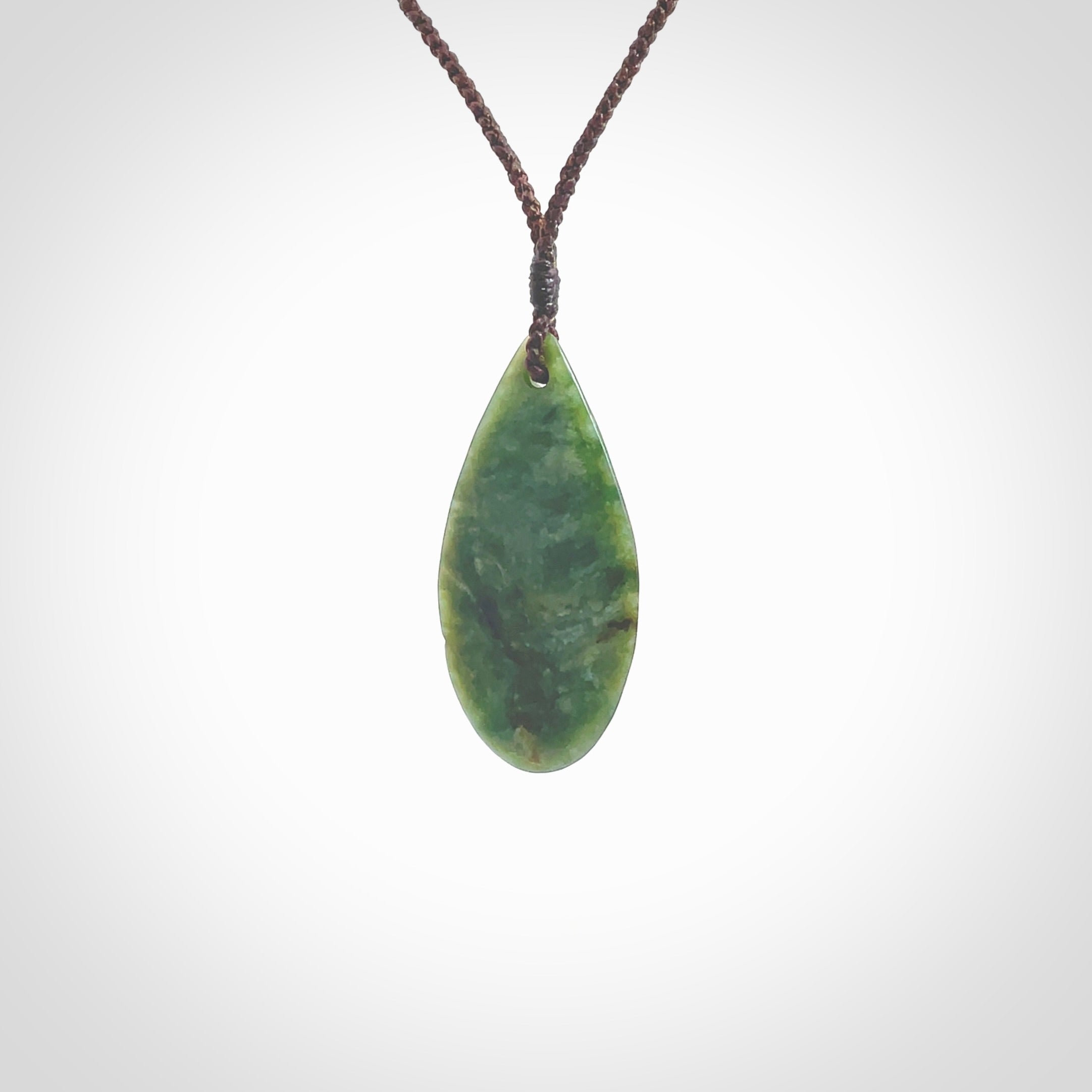 This photo shows a medium sized New Zealand jade drop shaped pendant. It a a lovely deep green jade. The cord is a four plait brown and is adjustable in length. One only medium, contemporary drop necklace from Jade, by Ric Moor.