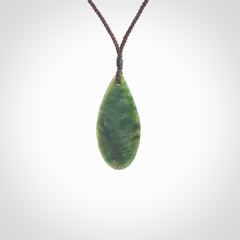 This photo shows a medium sized New Zealand jade drop shaped pendant. It a a lovely deep green jade. The cord is a four plait brown and is adjustable in length. One only medium, contemporary drop necklace from Jade, by Ric Moor.