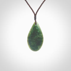 This photo shows a medium sized New Zealand jade drop shaped pendant. It a a lovely deep green jade. The cord is a four plait brown and is adjustable in length. One only medium, contemporary drop necklace from Jade, by Ric Moor.