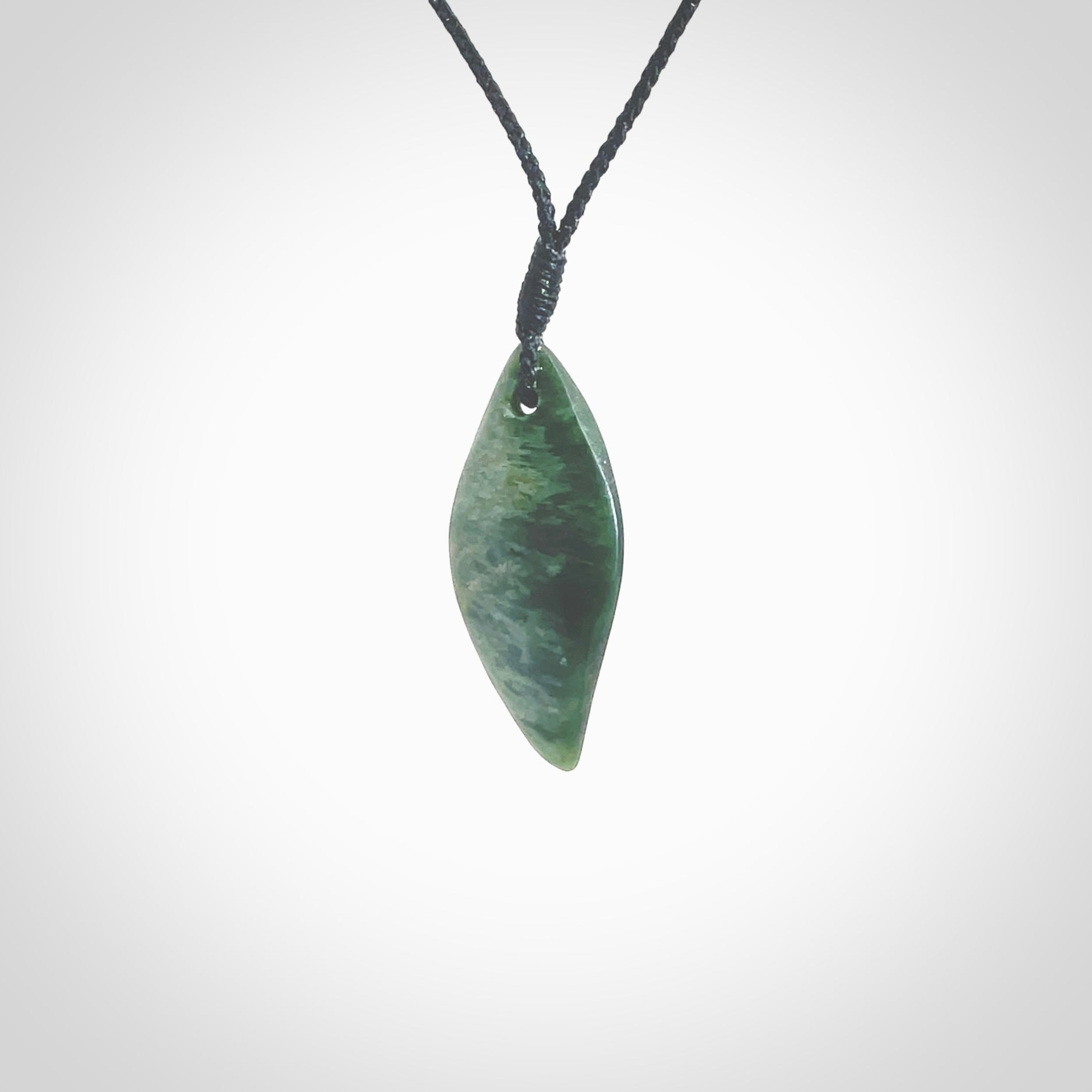 This photo shows a small jade drop shaped pendant. It a a lovely deep green jade. The cord is a four plait black and is adjustable in length. One only small, contemporary drop necklace from Jade, by Ric Moor.