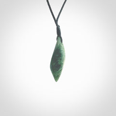 This photo shows a small jade drop shaped pendant. It a a lovely deep green jade. The cord is a four plait black and is adjustable in length. One only small, contemporary drop necklace from Jade, by Ric Moor.