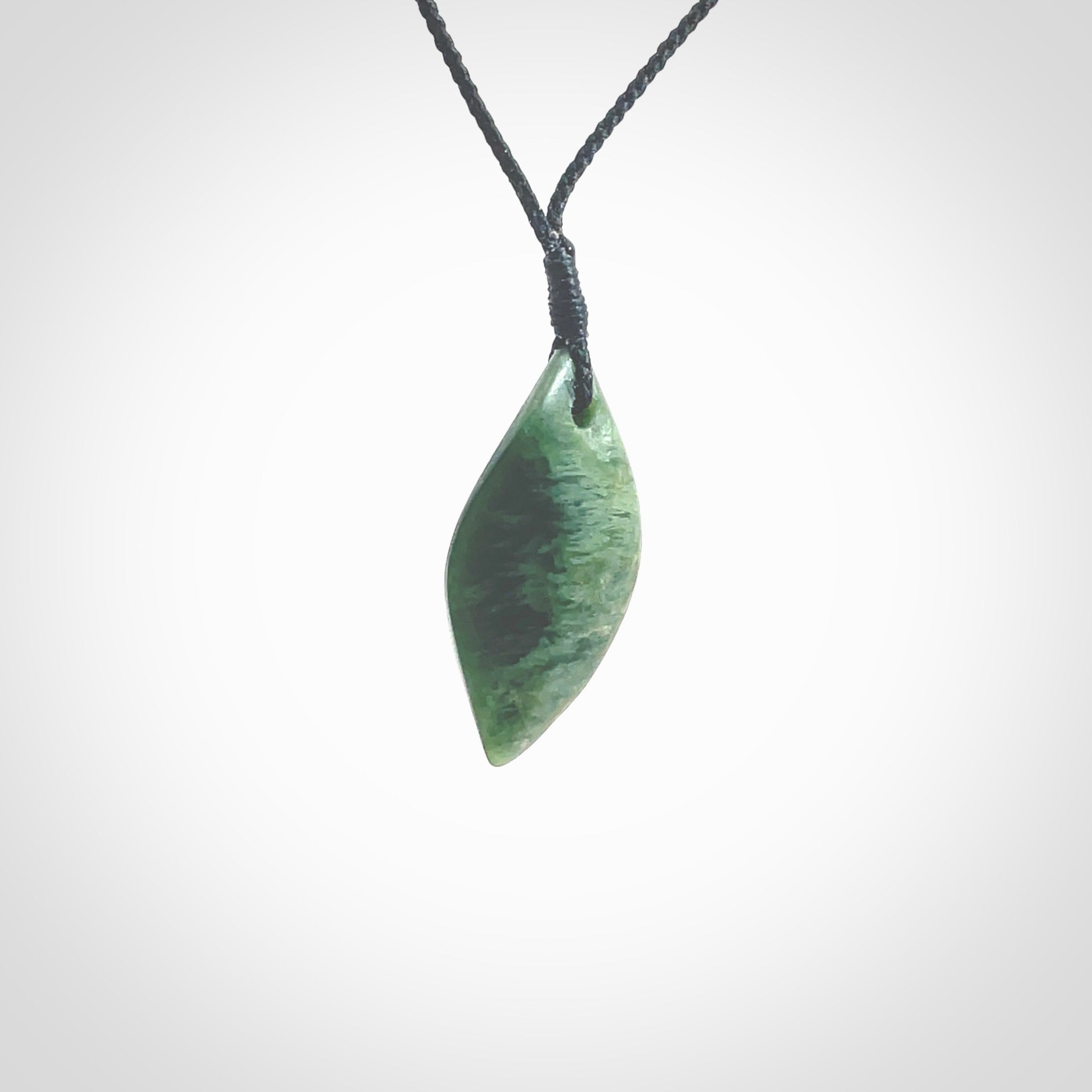 This photo shows a small jade drop shaped pendant. It a a lovely deep green jade. The cord is a four plait black and is adjustable in length. One only small, contemporary drop necklace from Jade, by Ric Moor.