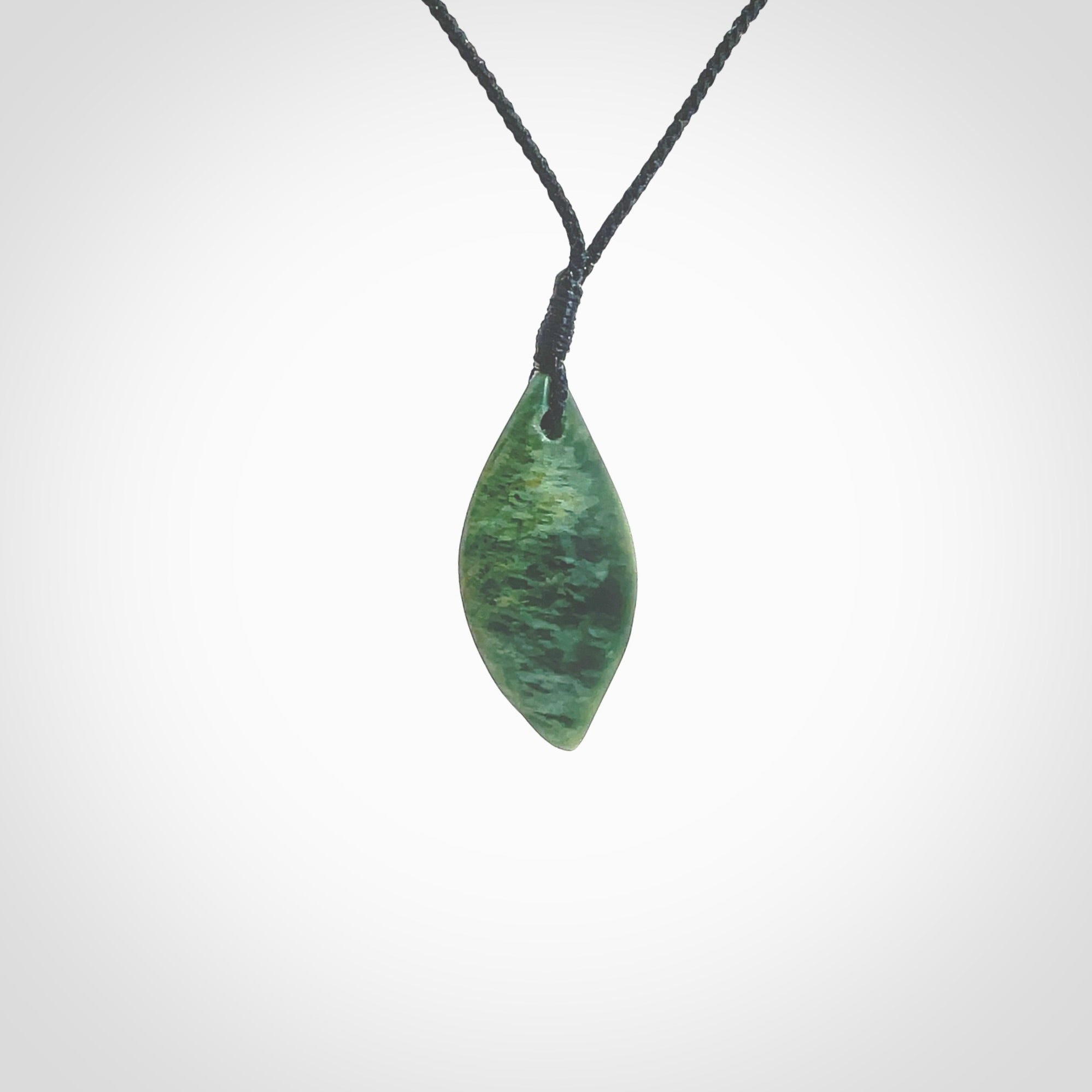 This photo shows a small jade drop shaped pendant. It a a lovely deep green jade. The cord is a four plait black and is adjustable in length. One only small, contemporary drop necklace from Jade, by Ric Moor.