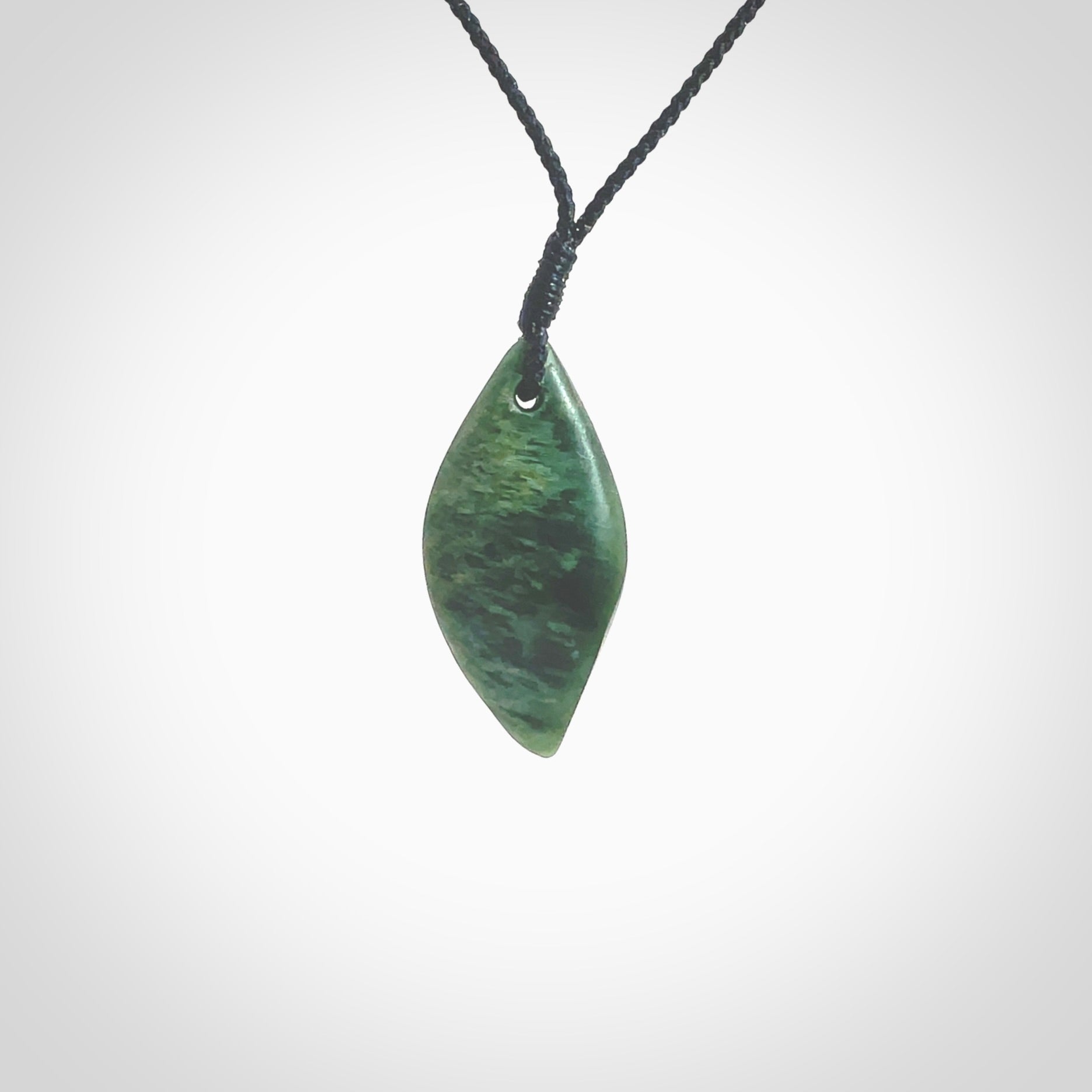 This photo shows a small jade drop shaped pendant. It a a lovely deep green jade. The cord is a four plait black and is adjustable in length. One only small, contemporary drop necklace from Jade, by Ric Moor.