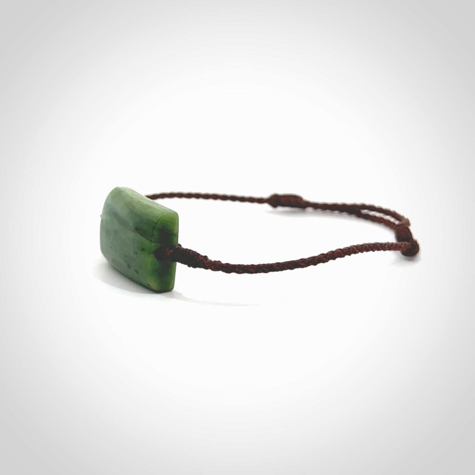 Hand carved New Zealand jade adjustable bracelet with brown cord. Carved in New Zealand jade by Ric Moor for NZ Pacific. One only armband for women and men.