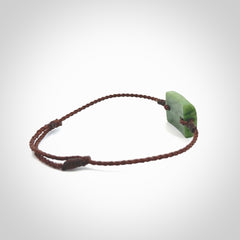 Hand carved New Zealand jade adjustable bracelet with brown cord. Carved in New Zealand jade by Ric Moor for NZ Pacific. One only armband for women and men.