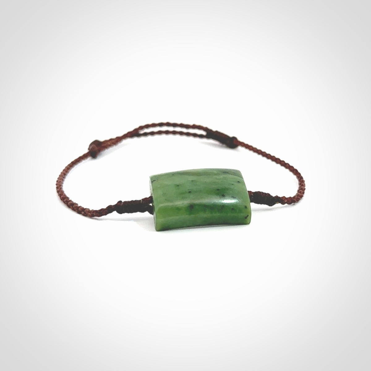 Hand carved New Zealand jade adjustable bracelet with brown cord. Carved in New Zealand jade by Ric Moor for NZ Pacific. One only armband for women and men.