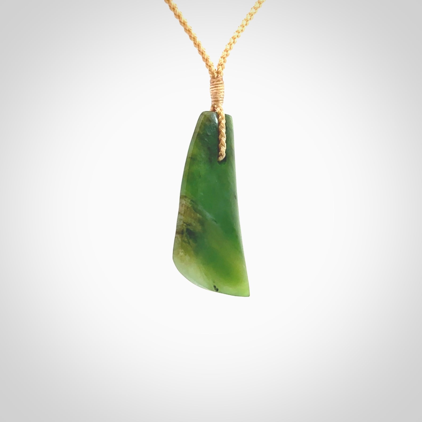 A lovely New Zealand jade drop pendant. This piece is made from a semi-translucent jade and is a wonderful deep green colour. Carved by Ric Moor for NZ Pacific and delivered worldwide. Provided with an adjustable beige cord.