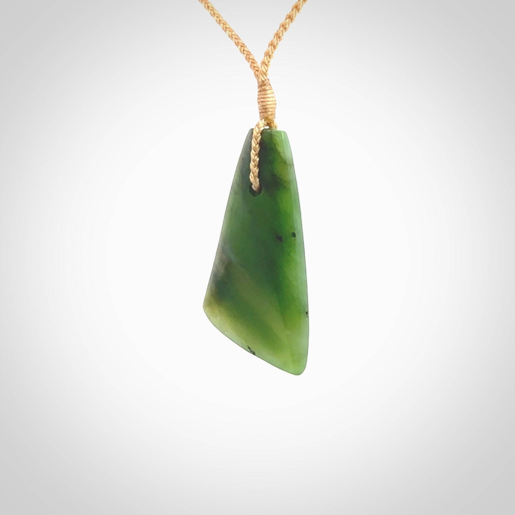 A lovely New Zealand jade drop pendant. This piece is made from a semi-translucent jade and is a wonderful deep green colour. Carved by Ric Moor for NZ Pacific and delivered worldwide. Provided with an adjustable beige cord.