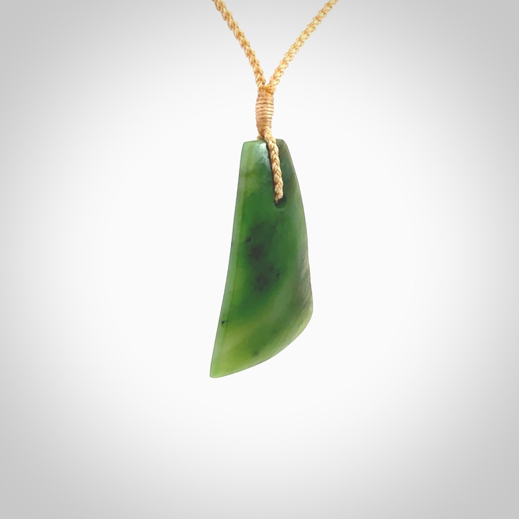 A lovely New Zealand jade drop pendant. This piece is made from a semi-translucent jade and is a wonderful deep green colour. Carved by Ric Moor for NZ Pacific and delivered worldwide. Provided with an adjustable beige cord.