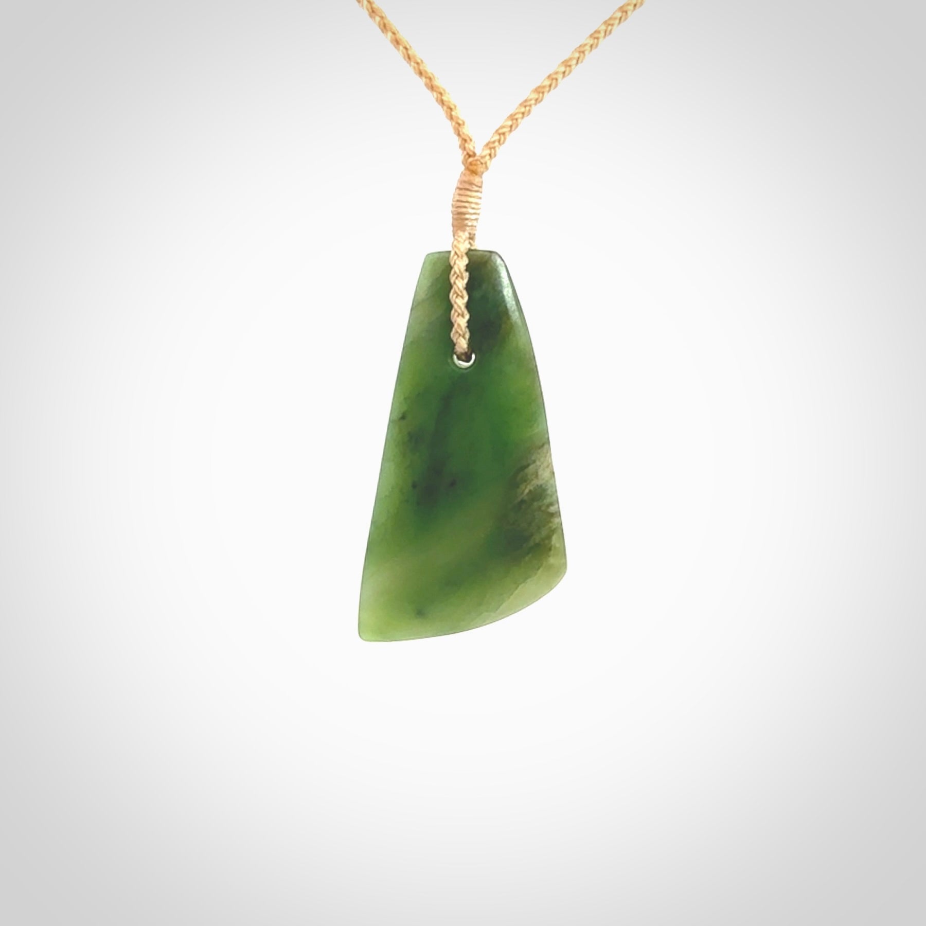 A lovely New Zealand jade drop pendant. This piece is made from a semi-translucent jade and is a wonderful deep green colour. Carved by Ric Moor for NZ Pacific and delivered worldwide. Provided with an adjustable beige cord.