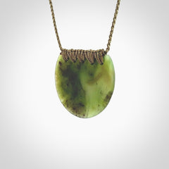 This piece is a disc pendant, hand carved for us by Ric Moor from a lovely milky green piece of New Zealand jade. It is suspended on a olive coloured braided cord that is length adjustable.