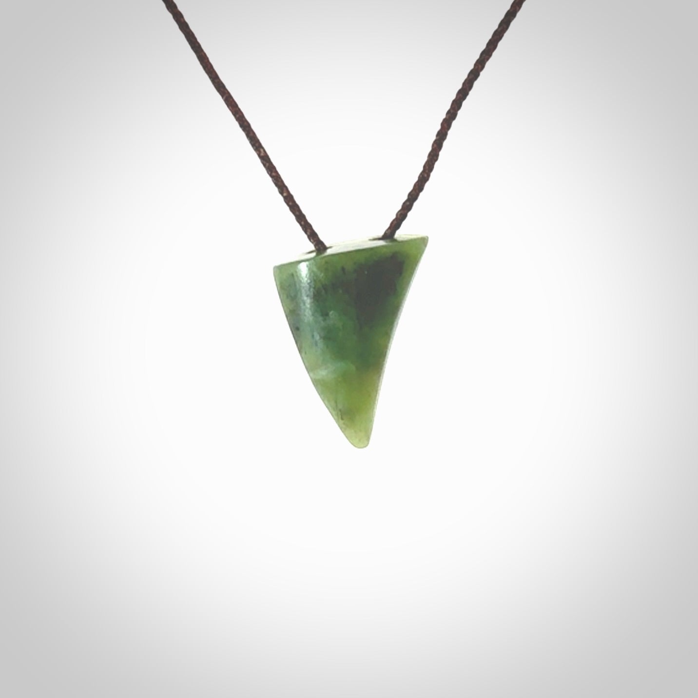 This is a lovely New Zealand Jade, pounamu drop pendant. Hand carved for us by Ric Moor. It is bound with an adjustable brown coloured cord which is length adjustable. Free worldwide shipping.