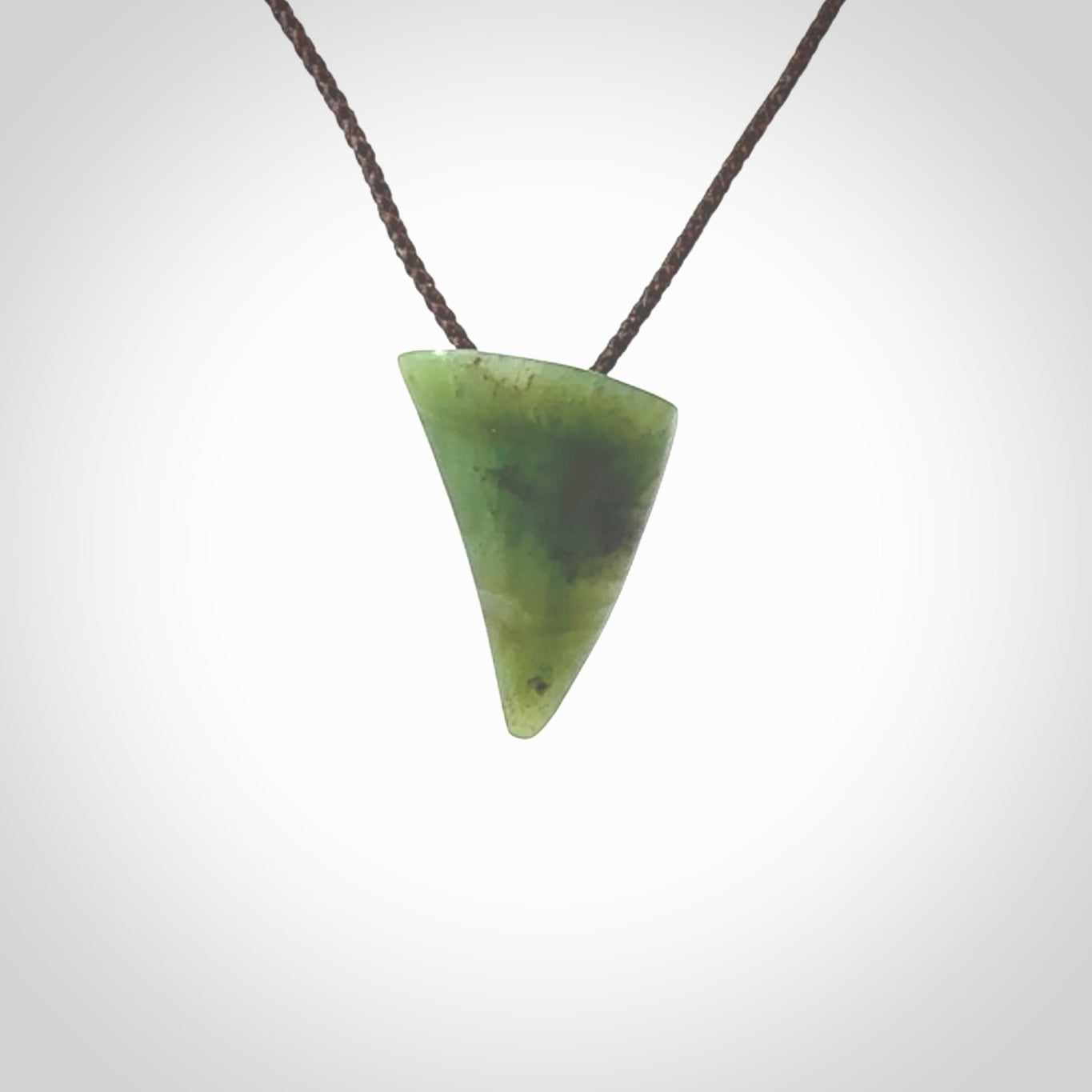 This is a lovely New Zealand Jade, pounamu drop pendant. Hand carved for us by Ric Moor. It is bound with an adjustable brown coloured cord which is length adjustable. Free worldwide shipping.