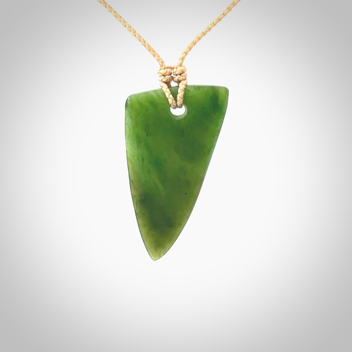 A lovely New Zealand jade drop pendant. This piece is made from a semi-translucent jade and is a wonderful deep green colour. Carved by Ric Moor for NZ Pacific and delivered worldwide. Provided with an adjustable beige cord.