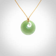 This is a small light green New Zealand Inanga jade koru pendant. We have bound this with a fine beige coloured cord necklace. The necklace is adjustable so you can position the piece where it suits you the best. Hand made by Ric Moor.