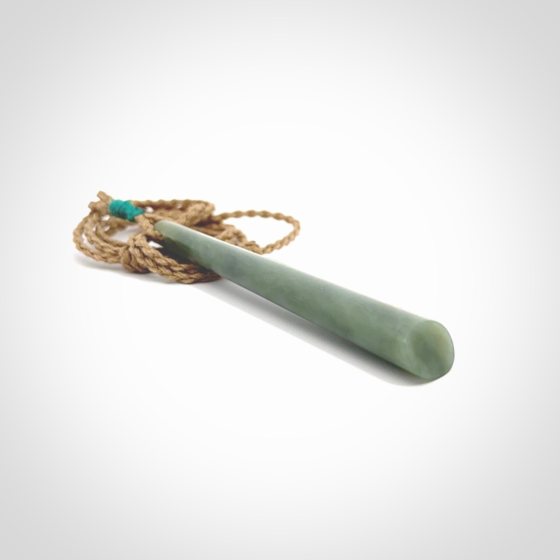 This photo shows a large Inanga jade drop shaped pendant. It is a lovely, stunning Inanga Pounamu. The cord is a four plait kalahari tan and is adjustable in length. One only large, contemporary drop necklace from Jade, by Rueben Tipene.