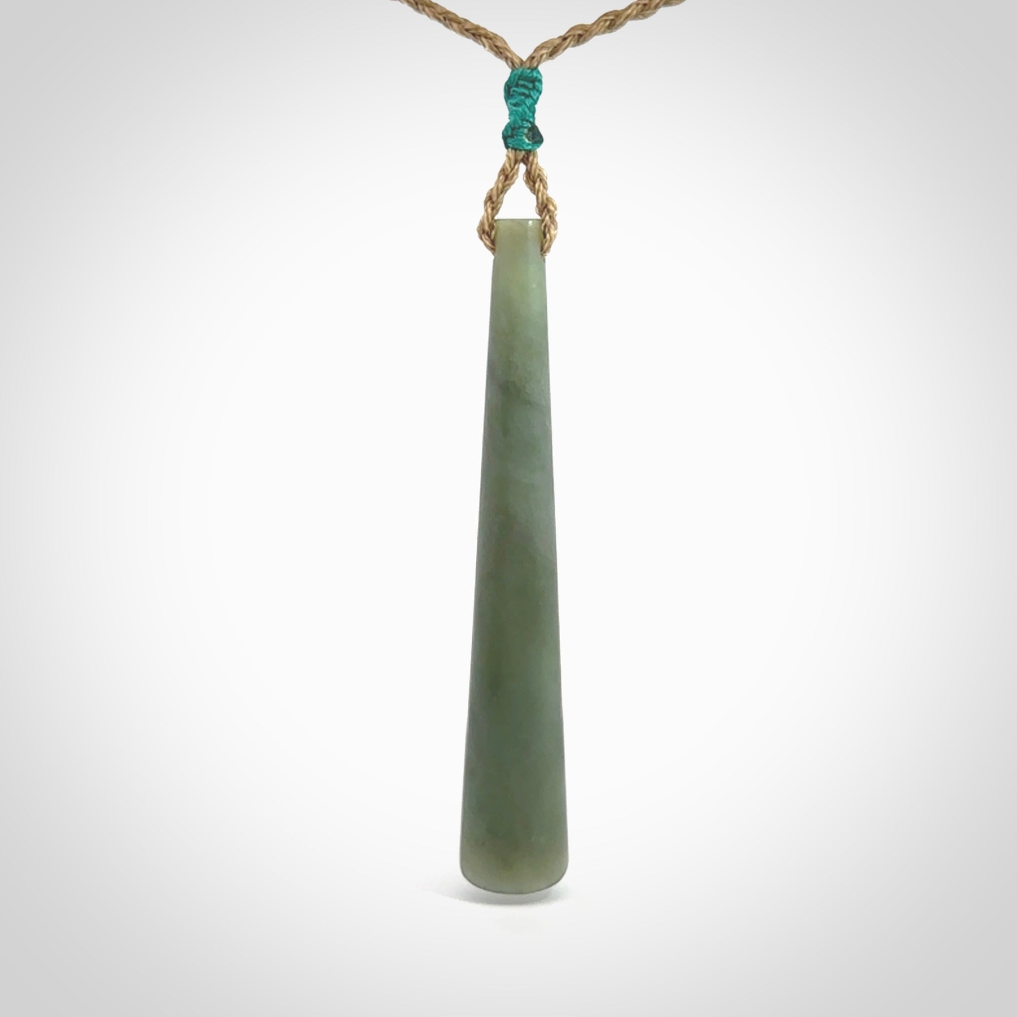 This photo shows a large Inanga jade drop shaped pendant. It is a lovely, stunning Inanga Pounamu. The cord is a four plait kalahari tan and is adjustable in length. One only large, contemporary drop necklace from Jade, by Rueben Tipene.