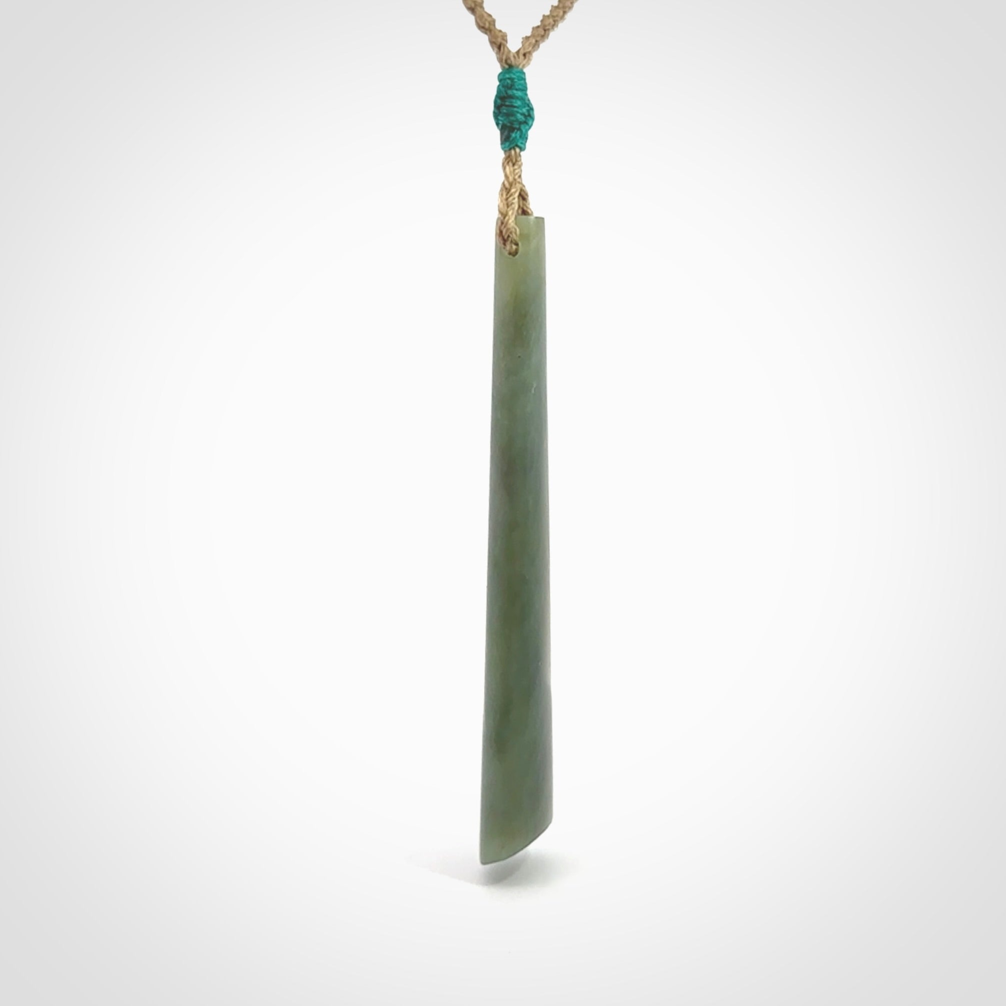 This photo shows a large Inanga jade drop shaped pendant. It is a lovely, stunning Inanga Pounamu. The cord is a four plait kalahari tan and is adjustable in length. One only large, contemporary drop necklace from Jade, by Rueben Tipene.