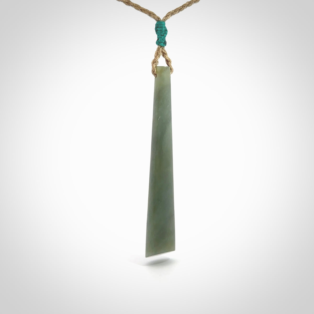 This photo shows a large Inanga jade drop shaped pendant. It is a lovely, stunning Inanga Pounamu. The cord is a four plait kalahari tan and is adjustable in length. One only large, contemporary drop necklace from Jade, by Rueben Tipene.