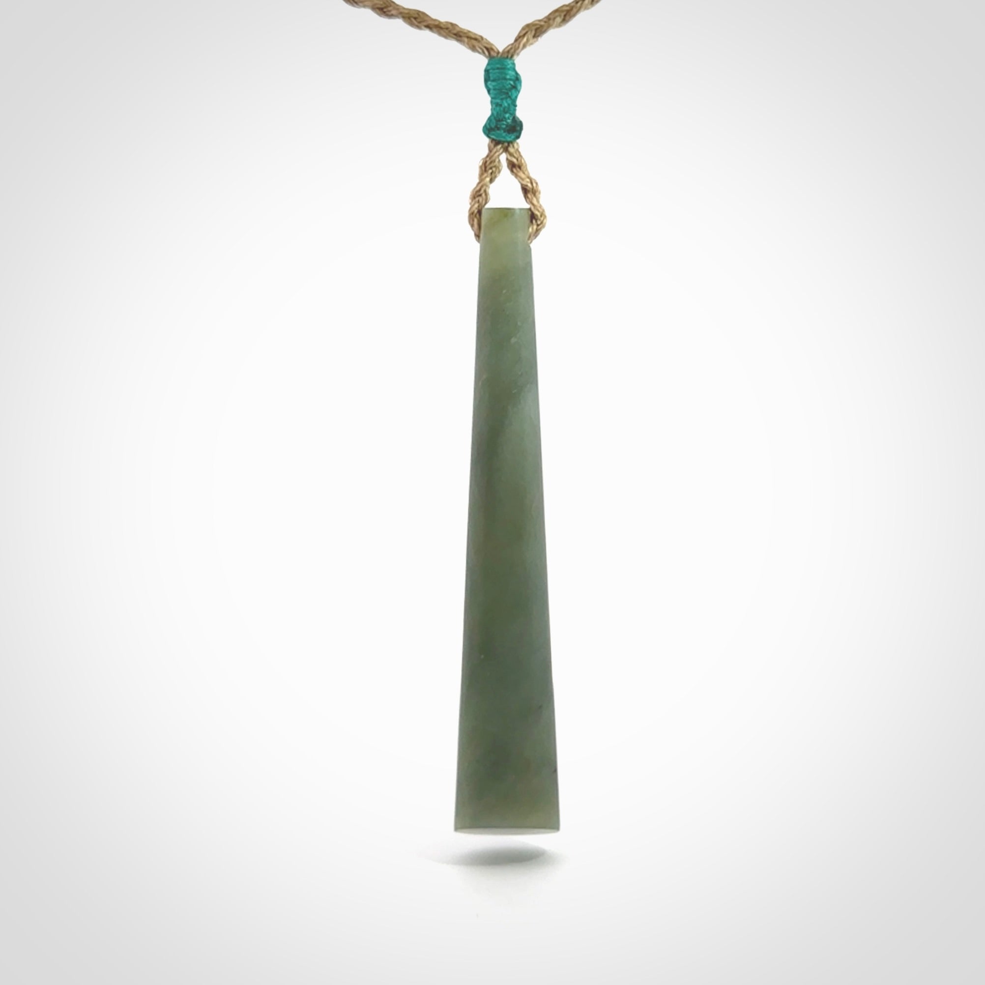 This photo shows a large Inanga jade drop shaped pendant. It is a lovely, stunning Inanga Pounamu. The cord is a four plait kalahari tan and is adjustable in length. One only large, contemporary drop necklace from Jade, by Rueben Tipene.