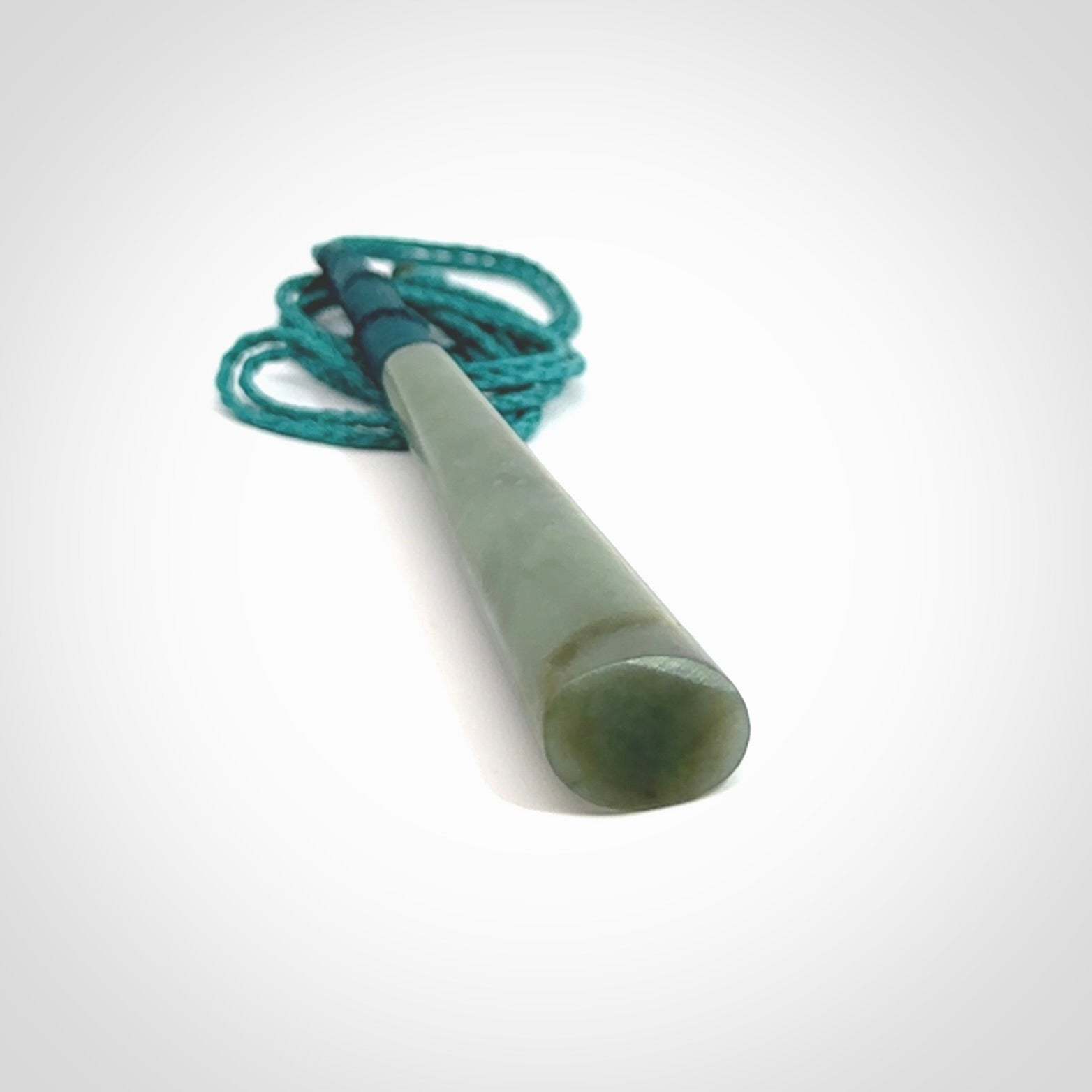 This photo shows a large Inanga jade drop shaped pendant. It is a lovely, stunning Inanga Pounamu. The cord is blue and is adjustable in length. One only large, contemporary drop necklace from Jade, by Rueben Tipene.