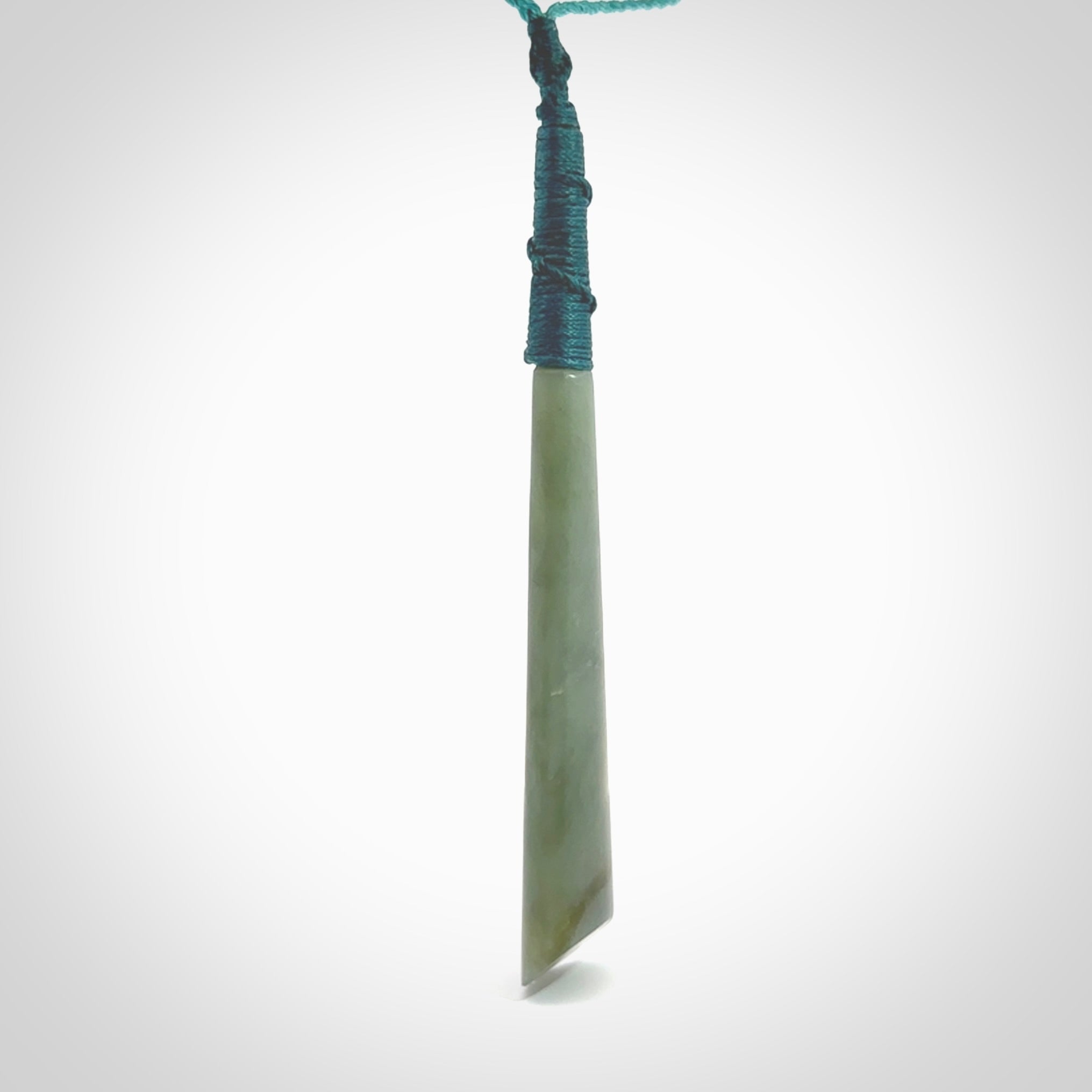 This photo shows a large Inanga jade drop shaped pendant. It is a lovely, stunning Inanga Pounamu. The cord is blue and is adjustable in length. One only large, contemporary drop necklace from Jade, by Rueben Tipene.