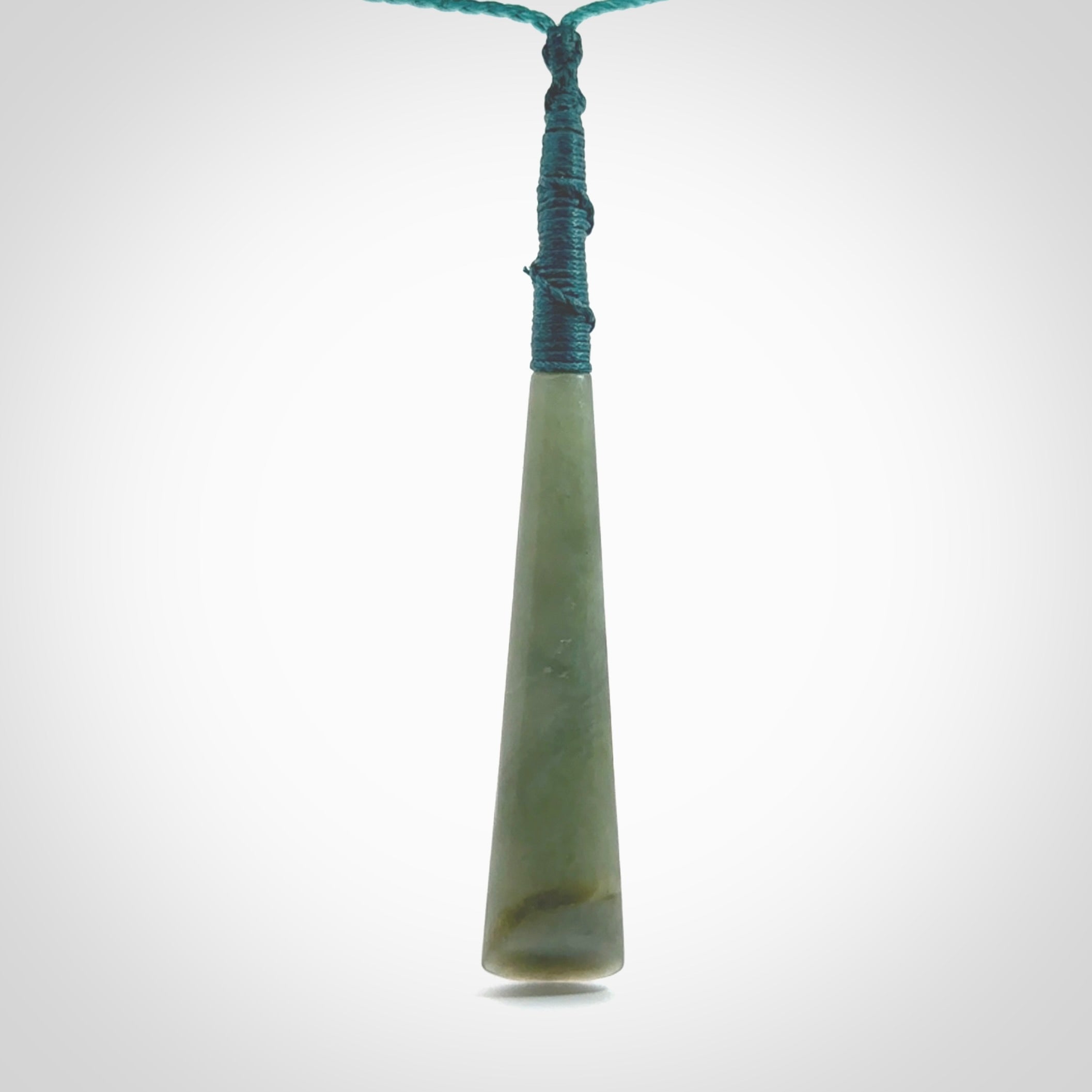 This photo shows a large Inanga jade drop shaped pendant. It is a lovely, stunning Inanga Pounamu. The cord is blue and is adjustable in length. One only large, contemporary drop necklace from Jade, by Rueben Tipene.