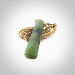 This photo shows a large Totoweka jade drop shaped pendant. It a a lovely, semi-translucent jade. The cord is tan and is adjustable in length. One only large, contemporary drop necklace from New Zealand Totoweka Jade, by Rueben Tipene.