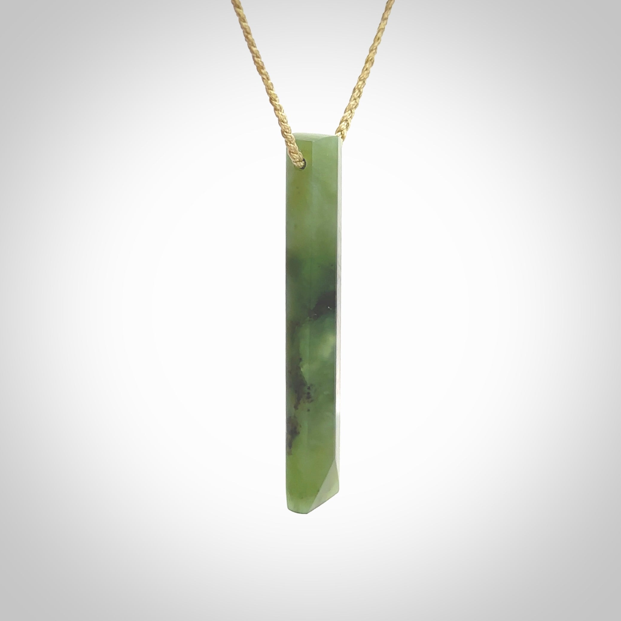 This photo shows a large Totoweka jade drop shaped pendant. It a a lovely, semi-translucent jade. The cord is tan and is adjustable in length. One only large, contemporary drop necklace from New Zealand Totoweka Jade, by Rueben Tipene.