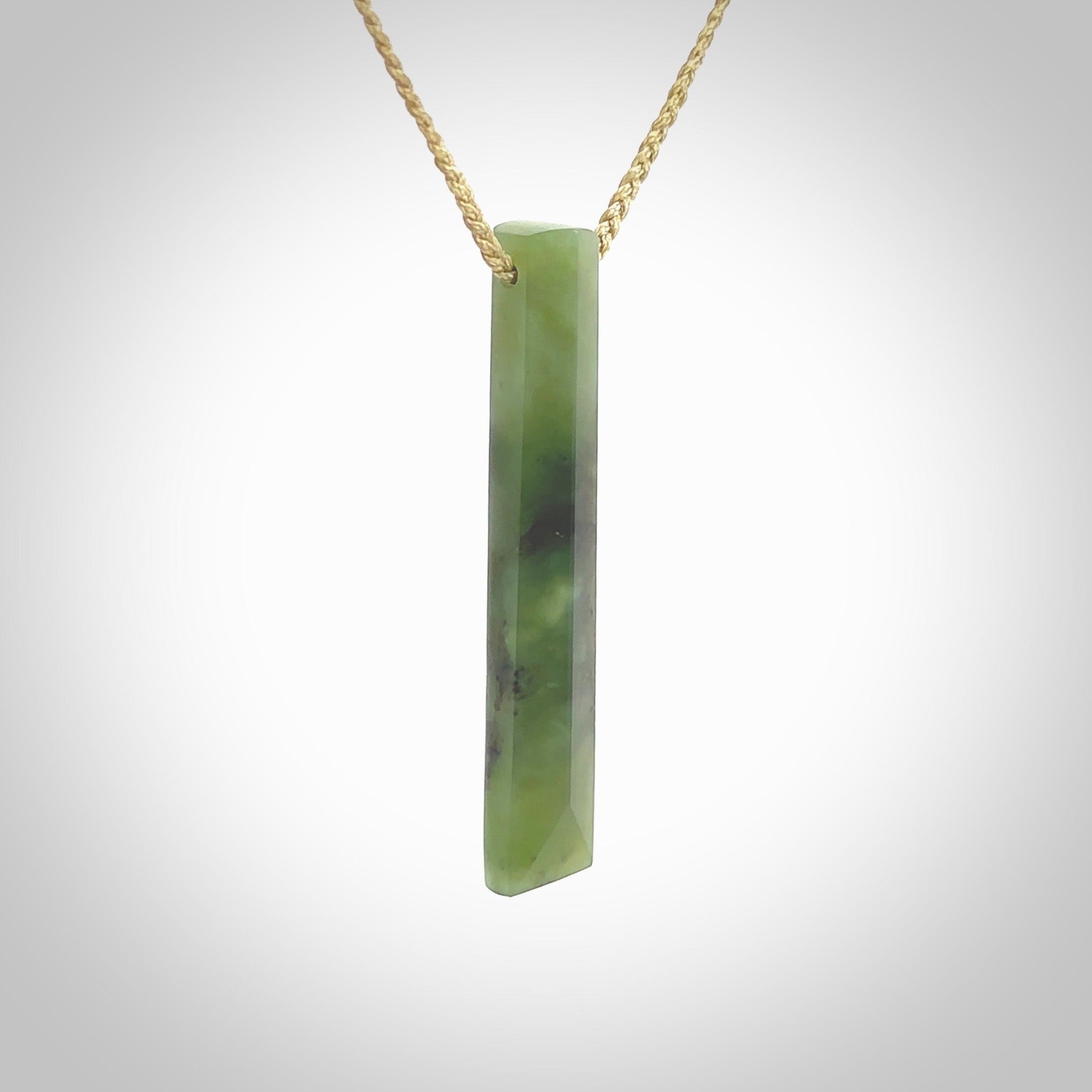 This photo shows a large Totoweka jade drop shaped pendant. It a a lovely, semi-translucent jade. The cord is tan and is adjustable in length. One only large, contemporary drop necklace from New Zealand Totoweka Jade, by Rueben Tipene.