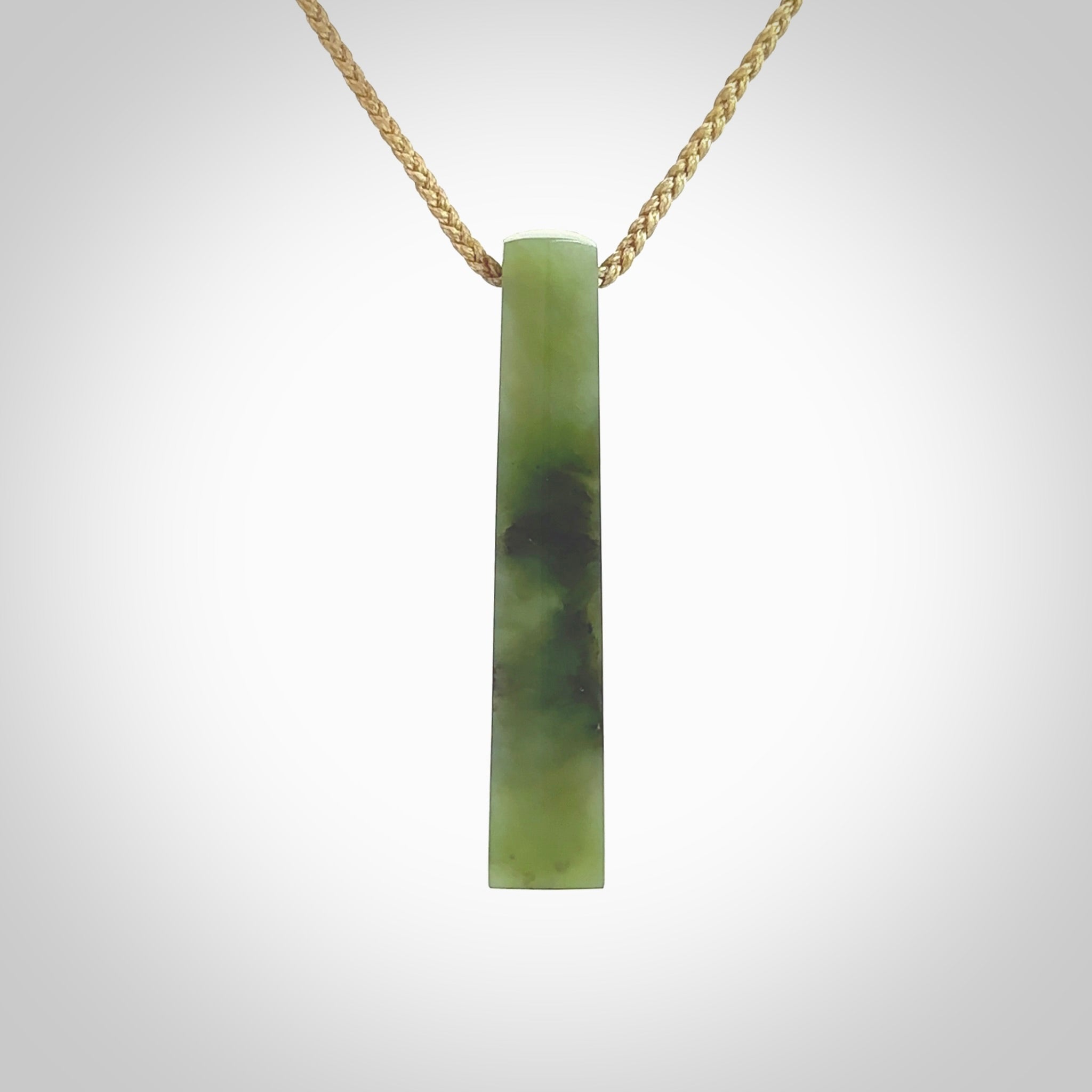 This photo shows a large Totoweka jade drop shaped pendant. It a a lovely, semi-translucent jade. The cord is tan and is adjustable in length. One only large, contemporary drop necklace from New Zealand Totoweka Jade, by Rueben Tipene.