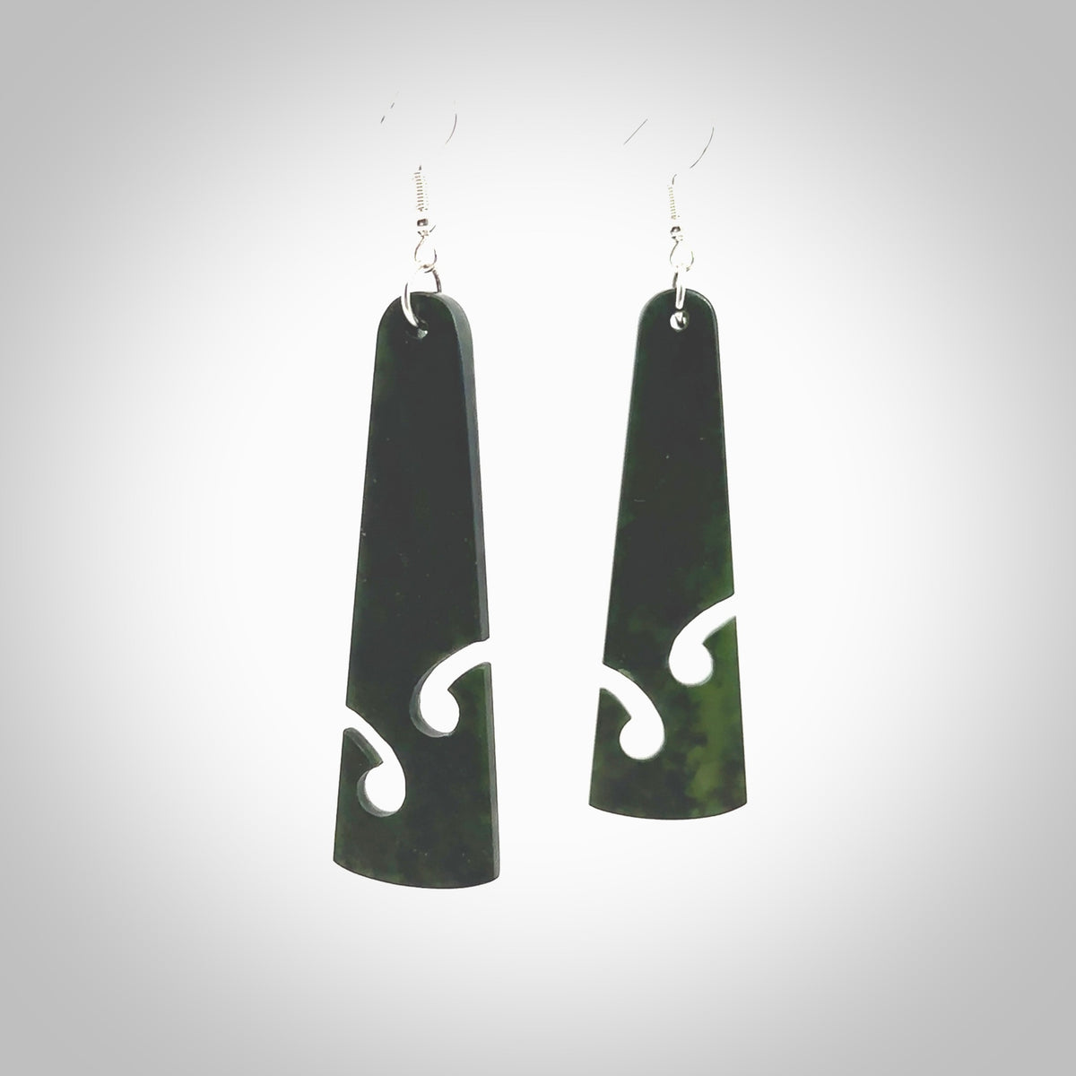 Hand carved by Rueben Tipene, these lovely koru jade earrings are hand made and an absolute delight. One pair only, postage is included in the price. Delivered to you in a woven kete pouch. New Zealand Jade drop earrings with koru.