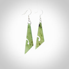 Hand carved by Rueben Tipene, these lovely koru jade earrings are hand made and an absolute delight. One pair only, postage is included in the price. Delivered to you in a woven kete pouch. New Zealand Jade drop earrings with koru.