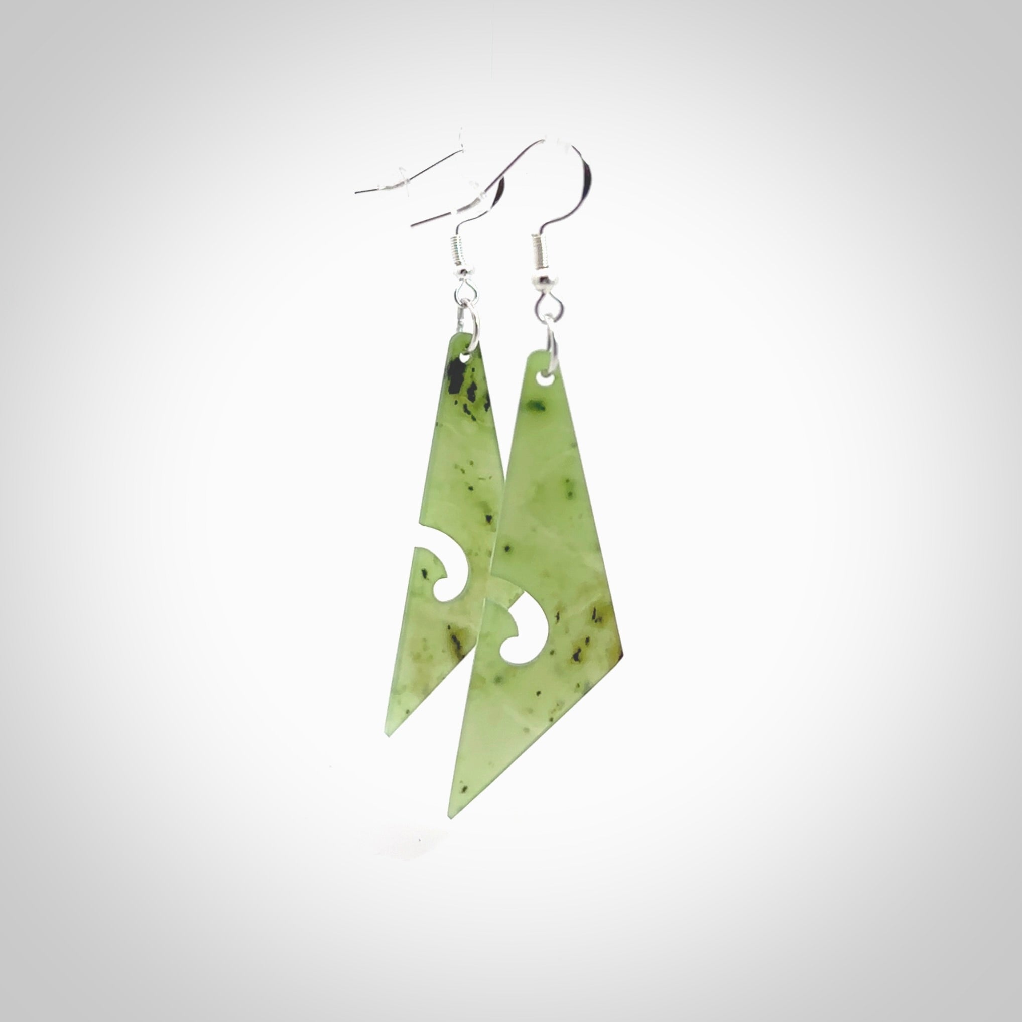 Hand carved by Rueben Tipene, these lovely koru jade earrings are hand made and an absolute delight. One pair only, postage is included in the price. Delivered to you in a woven kete pouch. New Zealand Jade drop earrings with koru.