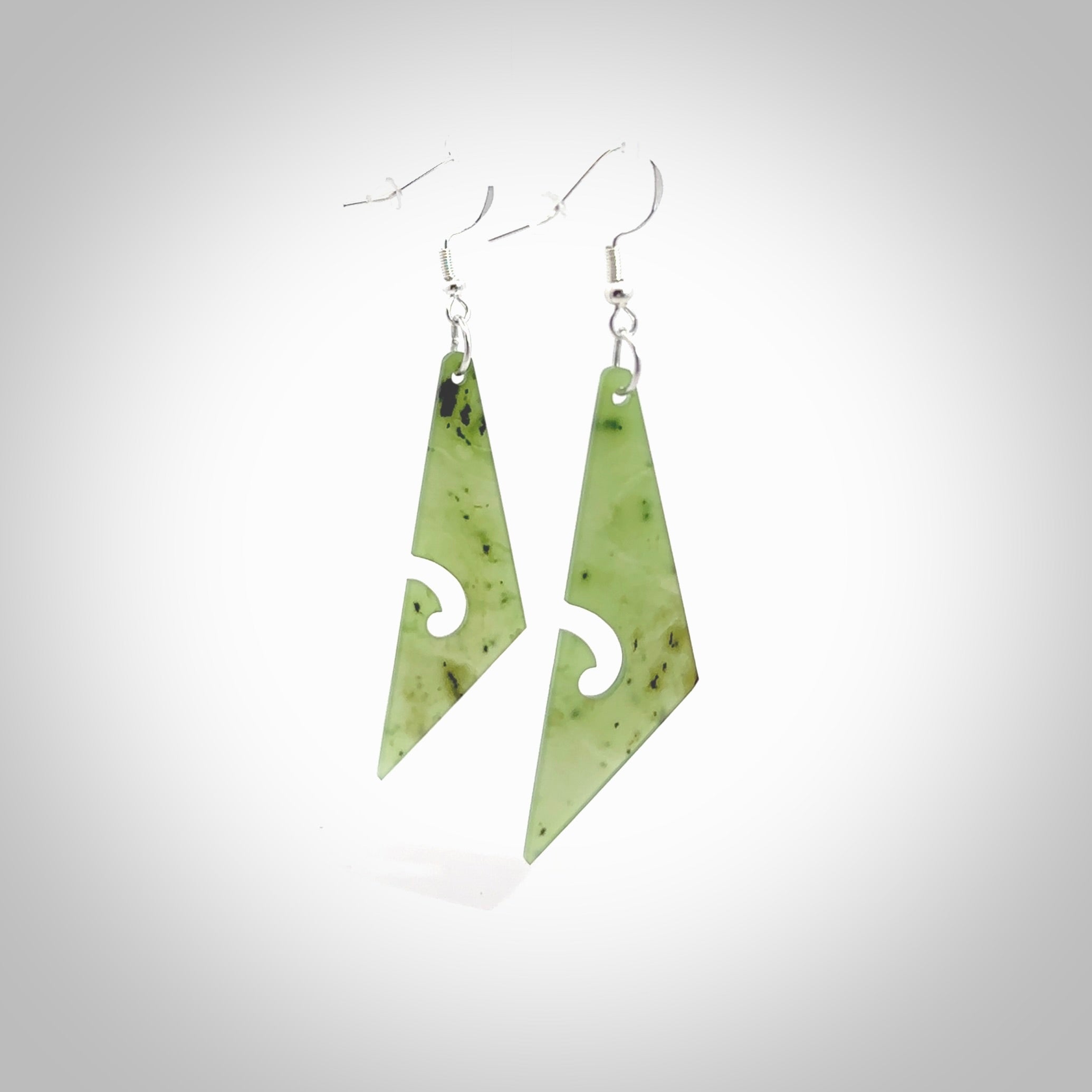 Hand carved by Rueben Tipene, these lovely koru jade earrings are hand made and an absolute delight. One pair only, postage is included in the price. Delivered to you in a woven kete pouch. New Zealand Jade drop earrings with koru.