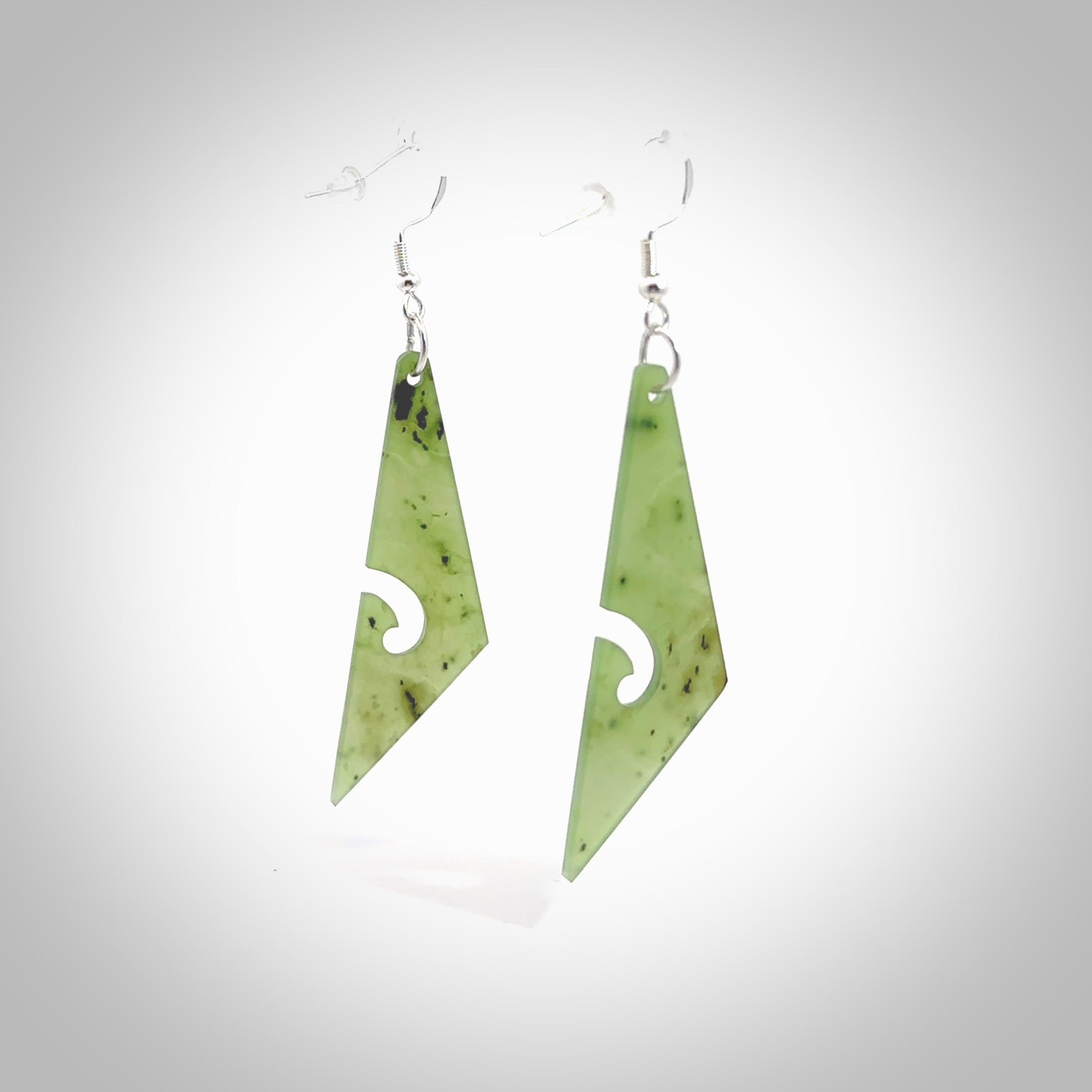 Hand carved by Rueben Tipene, these lovely koru jade earrings are hand made and an absolute delight. One pair only, postage is included in the price. Delivered to you in a woven kete pouch. New Zealand Jade drop earrings with koru.