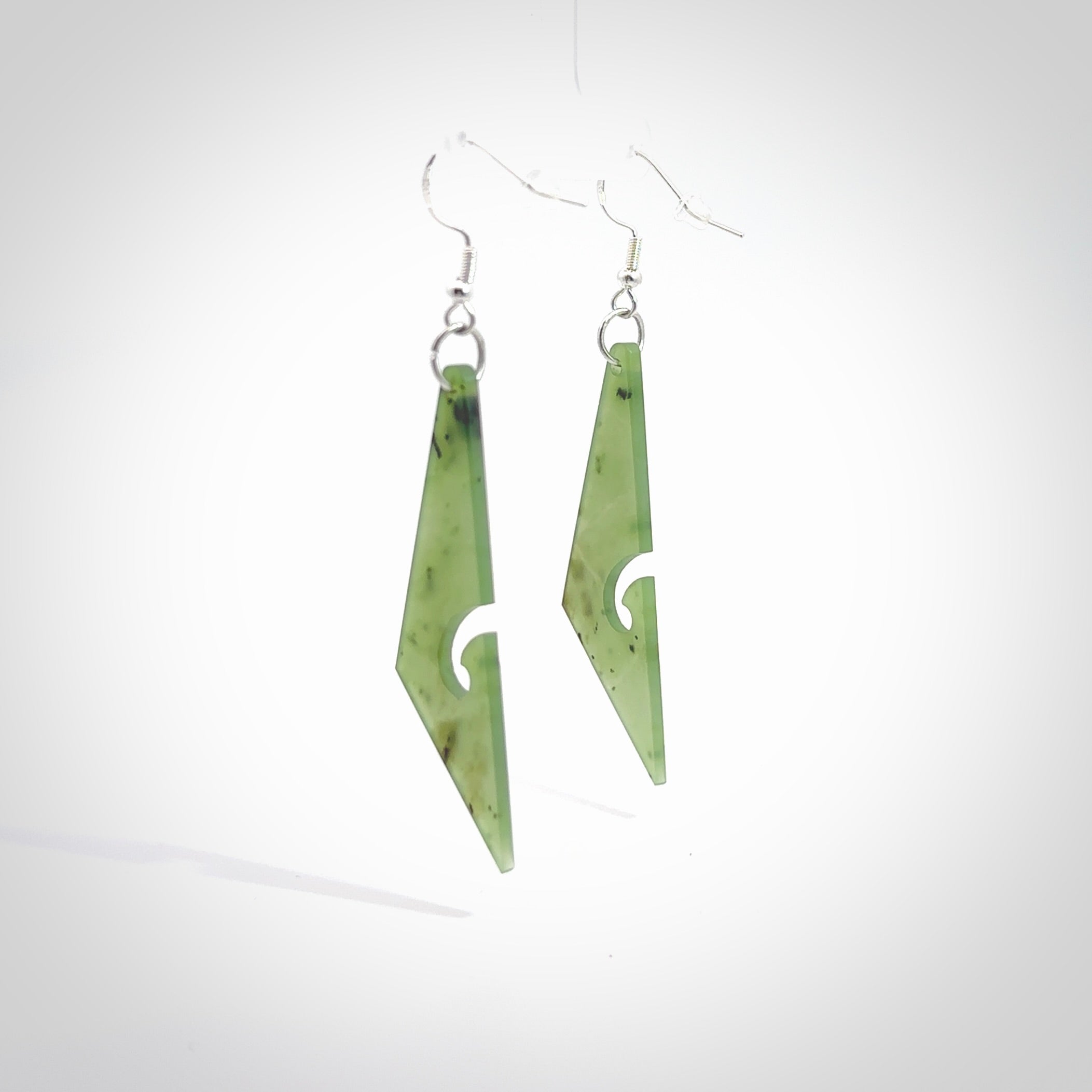 Hand carved by Rueben Tipene, these lovely koru jade earrings are hand made and an absolute delight. One pair only, postage is included in the price. Delivered to you in a woven kete pouch. New Zealand Jade drop earrings with koru.