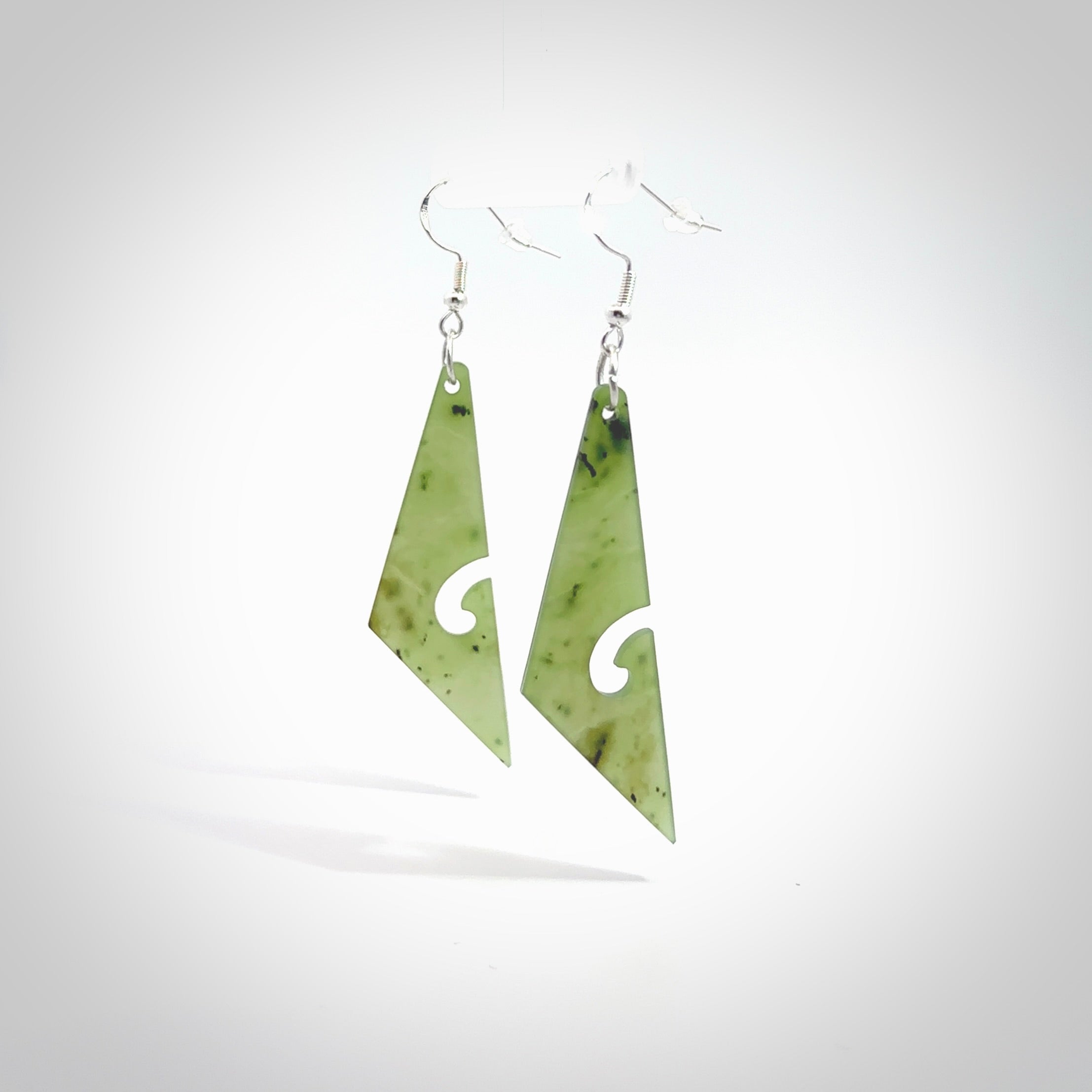 Hand carved by Rueben Tipene, these lovely koru jade earrings are hand made and an absolute delight. One pair only, postage is included in the price. Delivered to you in a woven kete pouch. New Zealand Jade drop earrings with koru.