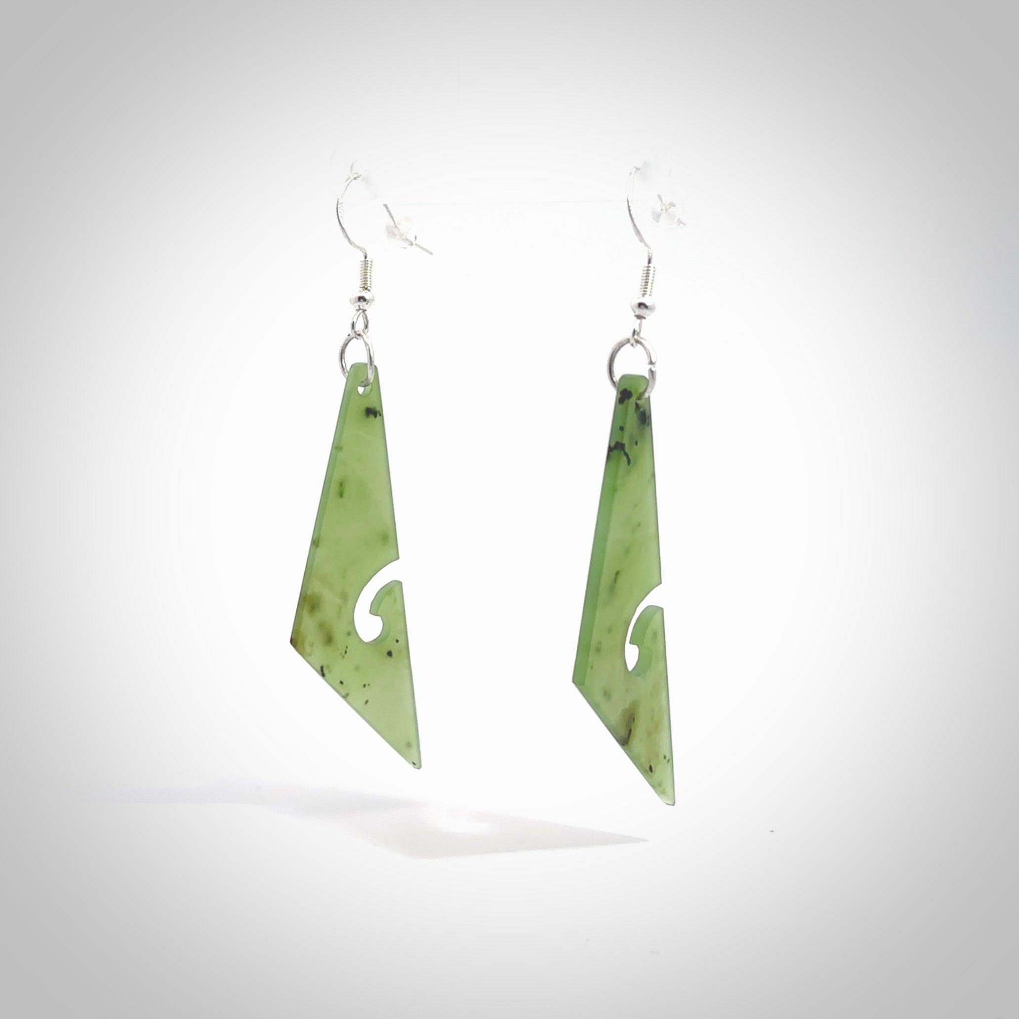 Hand carved by Rueben Tipene, these lovely koru jade earrings are hand made and an absolute delight. One pair only, postage is included in the price. Delivered to you in a woven kete pouch. New Zealand Jade drop earrings with koru.