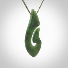 A hand carved hook design pendant, carved in New Zealand Kawakawa Jade. The colour is a beautiful deep green. The cord is khaki green and is length adjustable. Hand made by Rueben Tipene. Delivered with Express courier in a woven kete pouch.