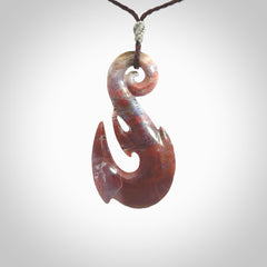 Large hook design pendant carved in Red Agate. Real Agate jewellery for sale online with NZ Pacific. Large hook pendant hand made in red agate, provided with adjustable cord and packaged in a woven kete pouch.